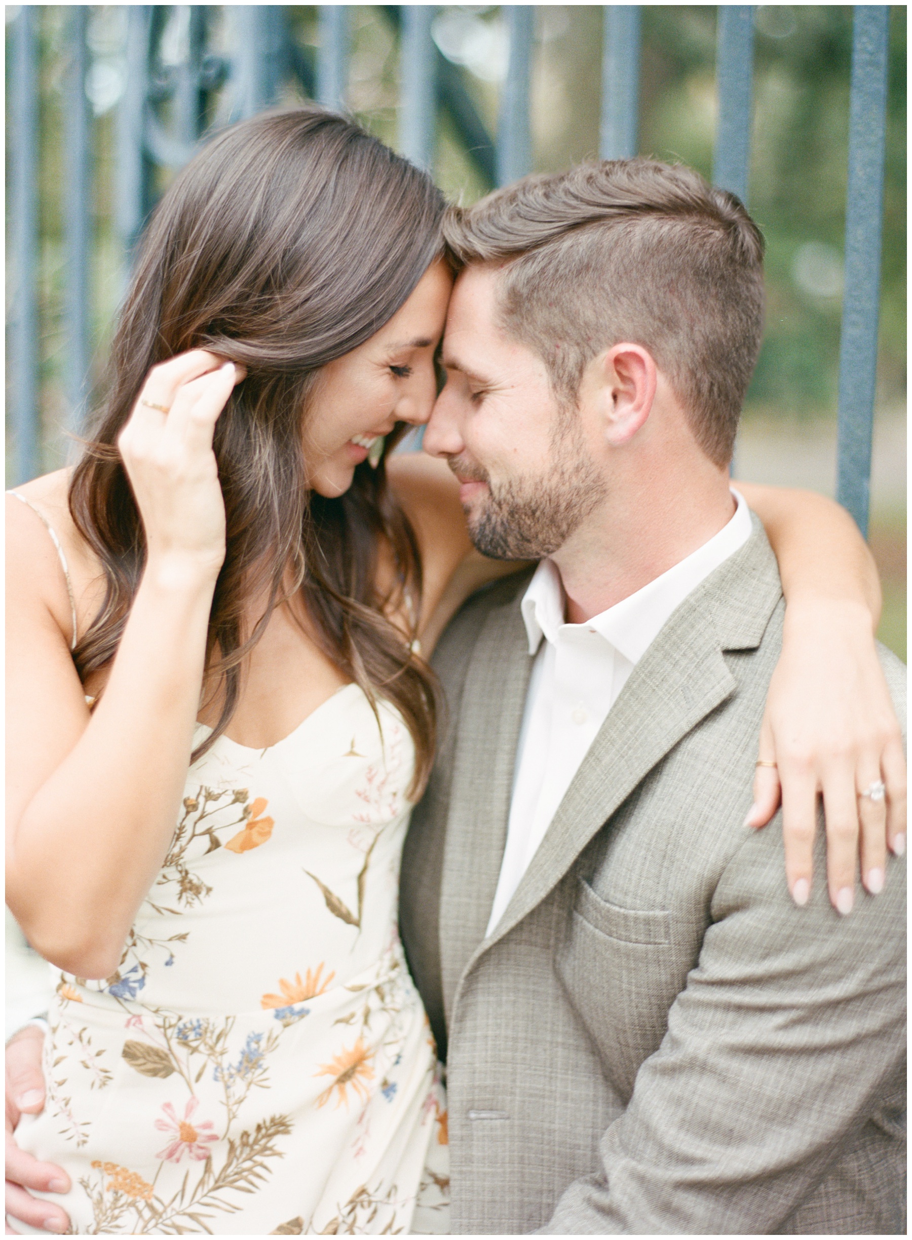 bride sits on groom's lap with arm around his shoulders while they nuzzle noses and laugh 