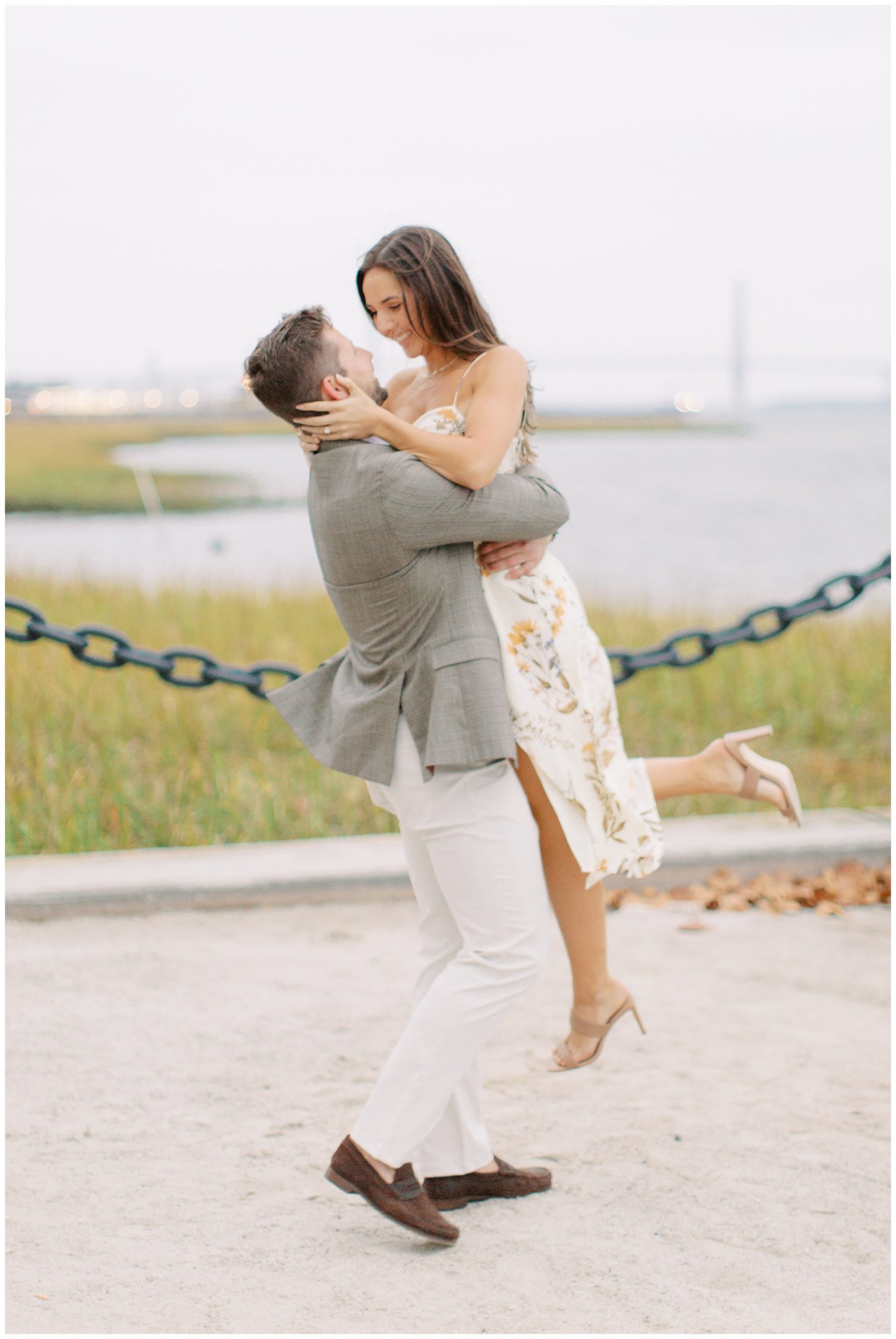 groom lifts up bride along waterfront in Charleston SC