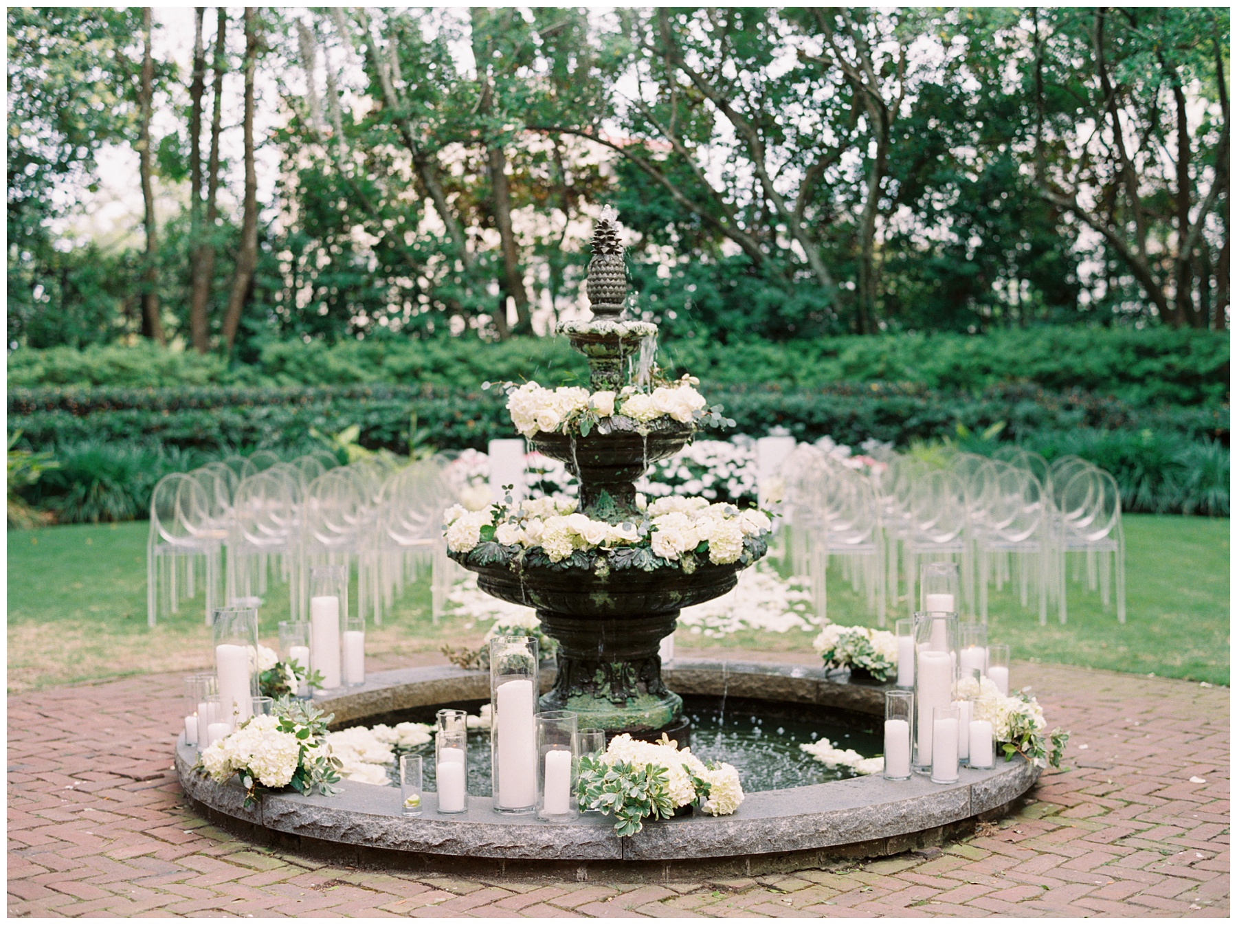 stone fountain in center of garden at the Governor Thomas Bennett House with white flowers and tall white candles around edge 