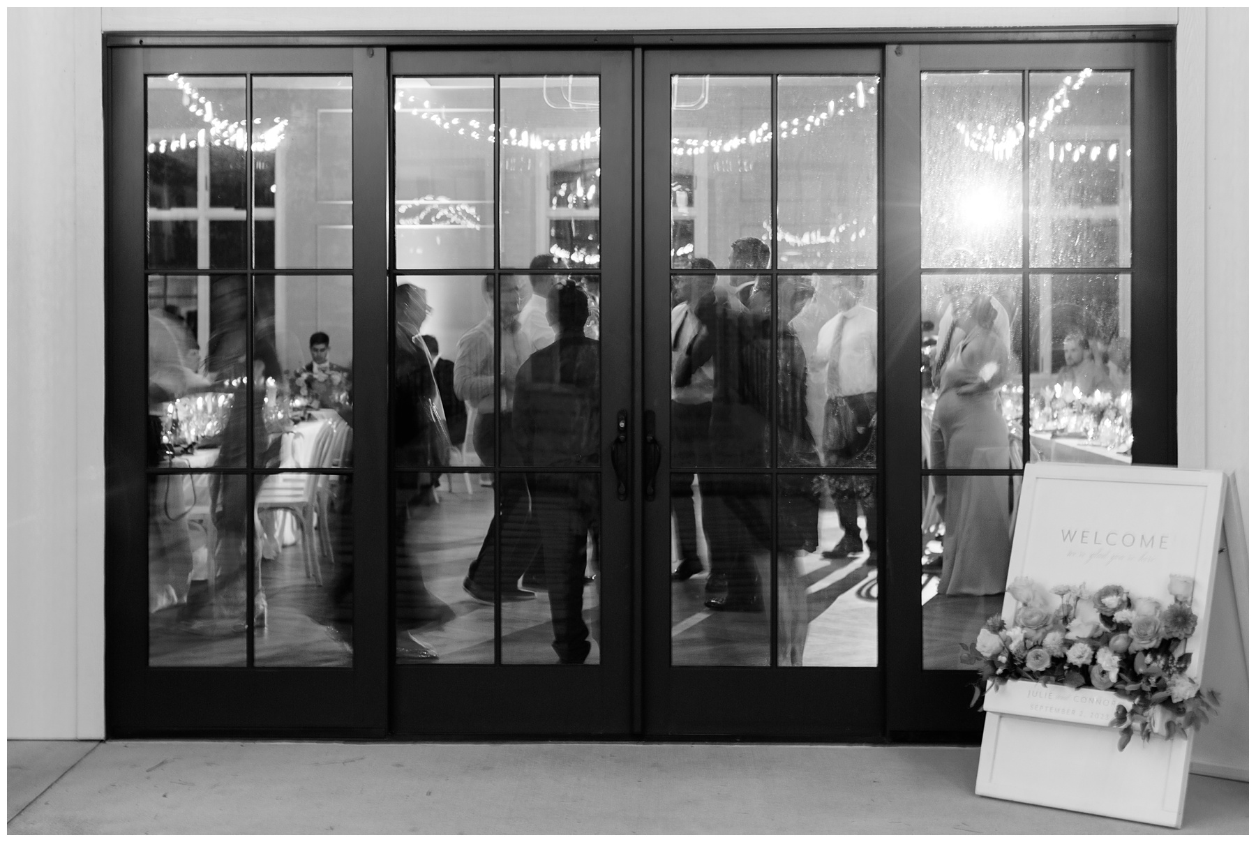 guest mingle inside reception behind glass and black doors at The Bradford