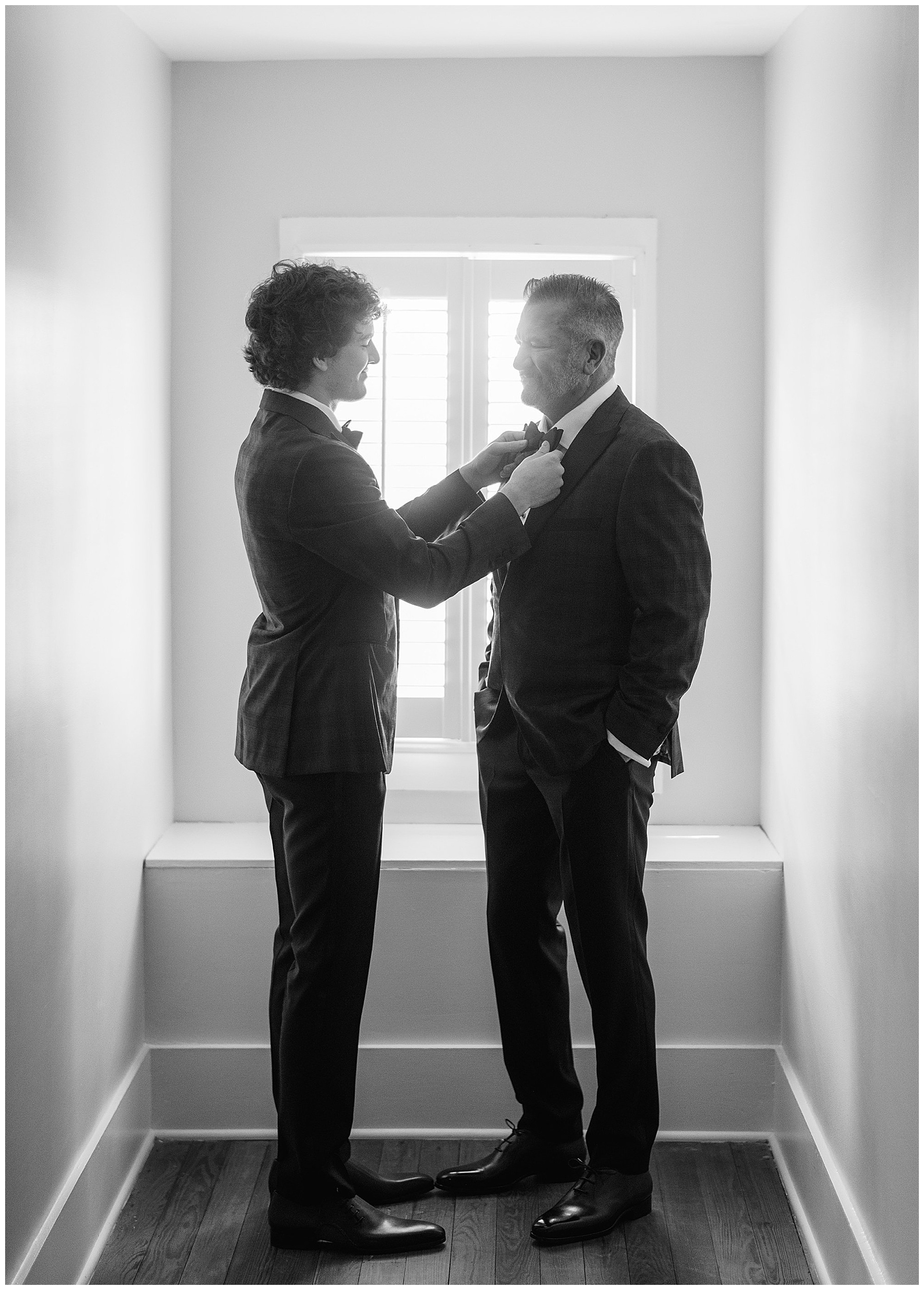 son adjusts bowtie for father during spring wedding at Lowndes Grove