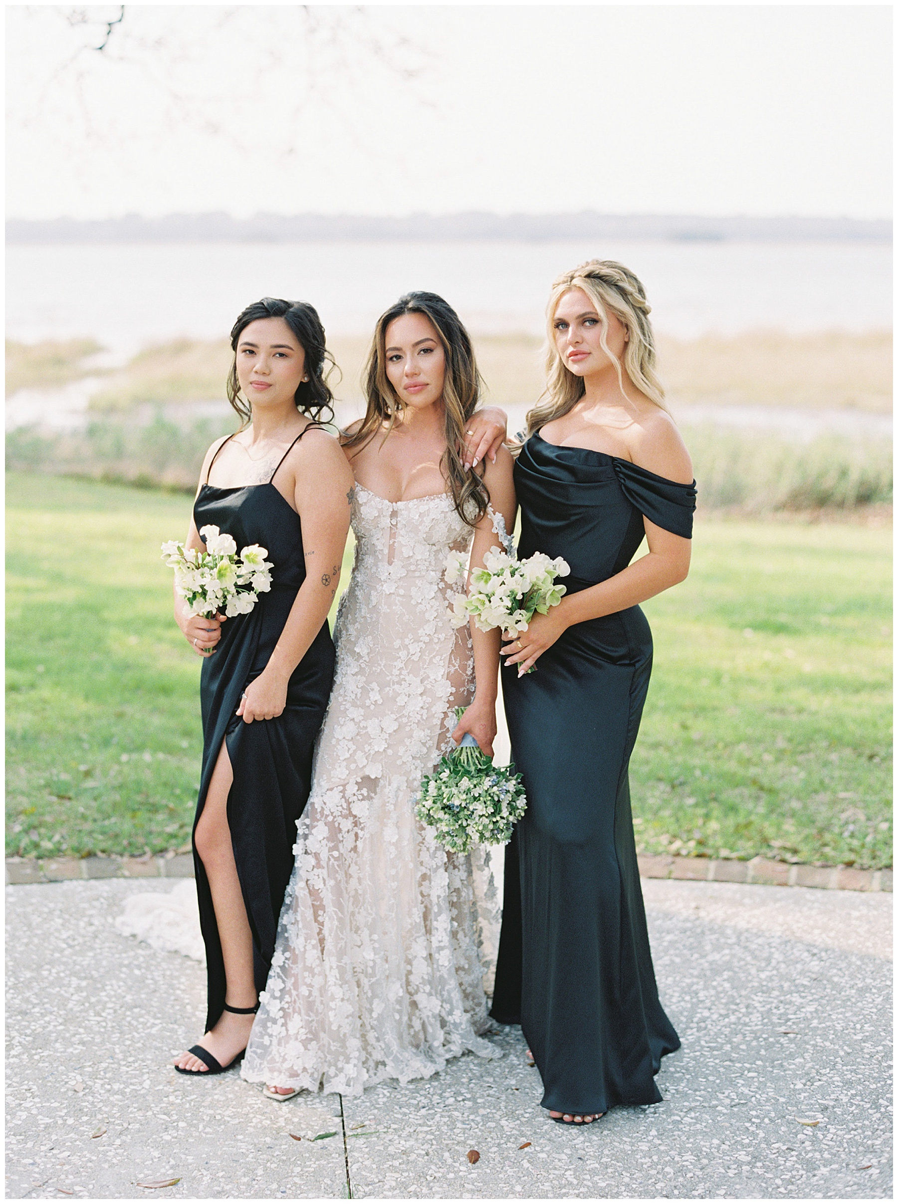 bride stands with bridesmaids in black gowns at Lowndes Grove