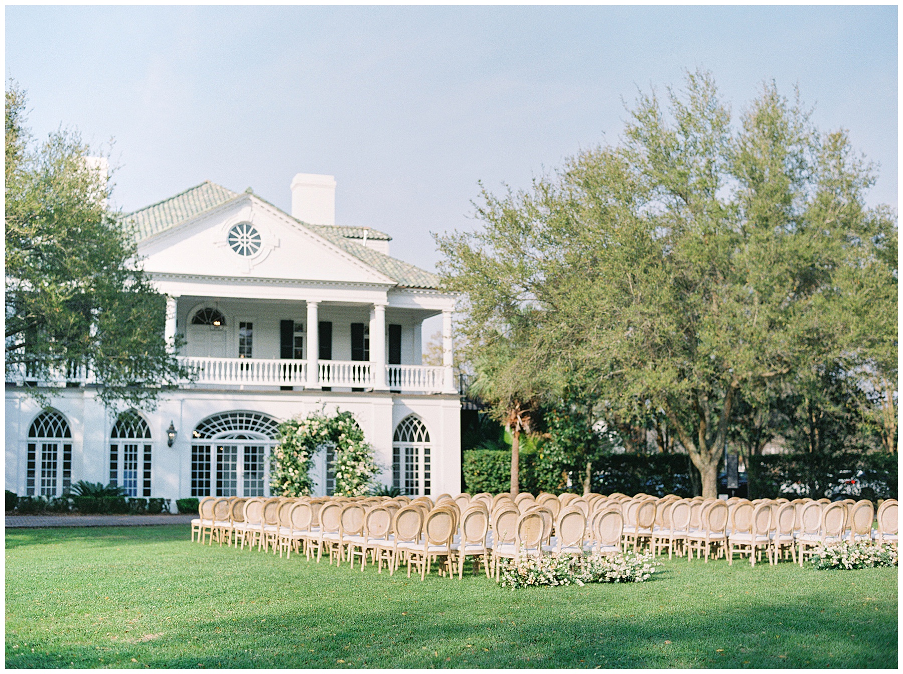 springtime at Lowndes Grove for wedding ceremony with wooden chairs and pastel flowers on lawn 