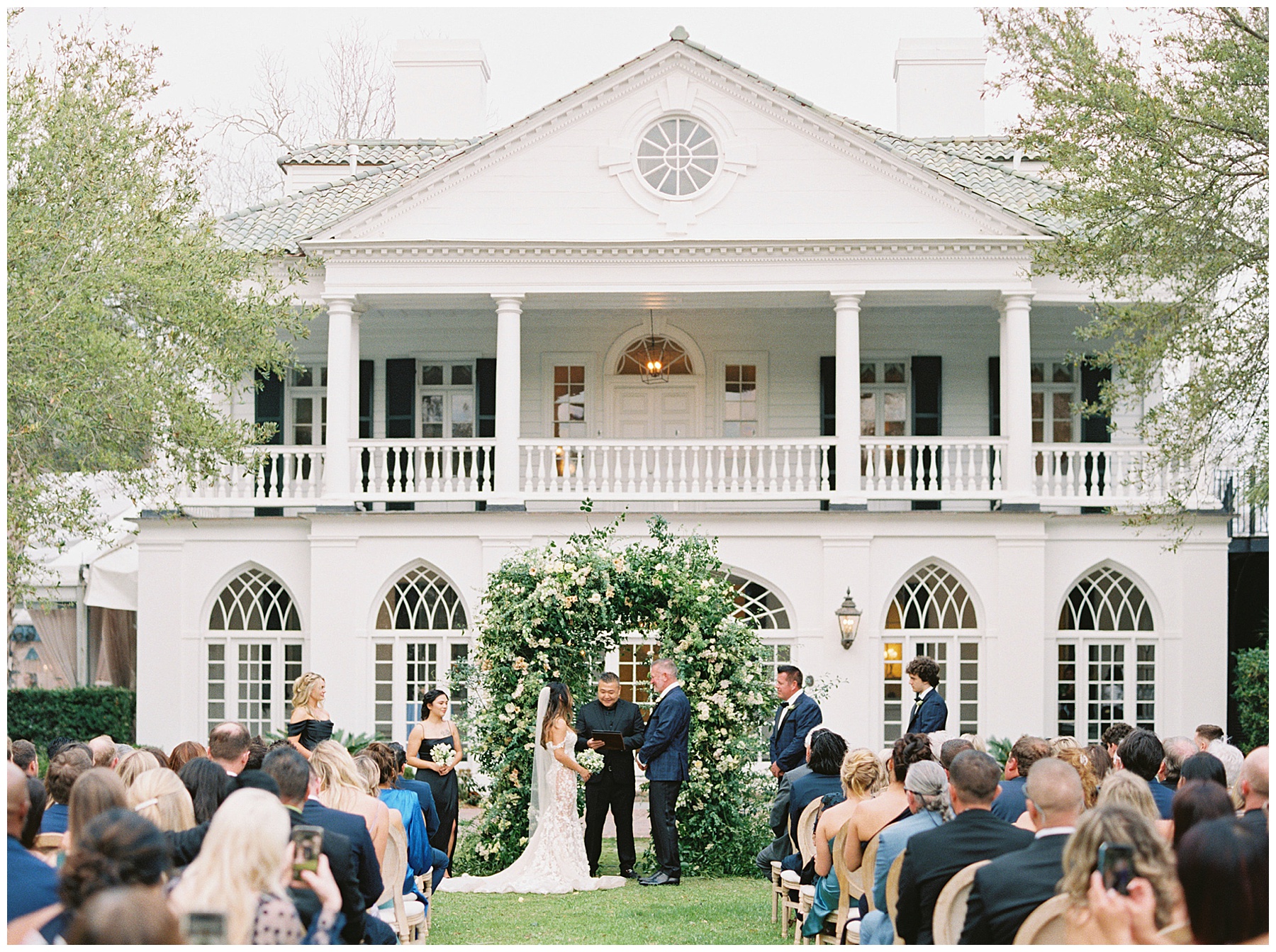 bride and groom exchange vows in front of white house at Lowndes Grove