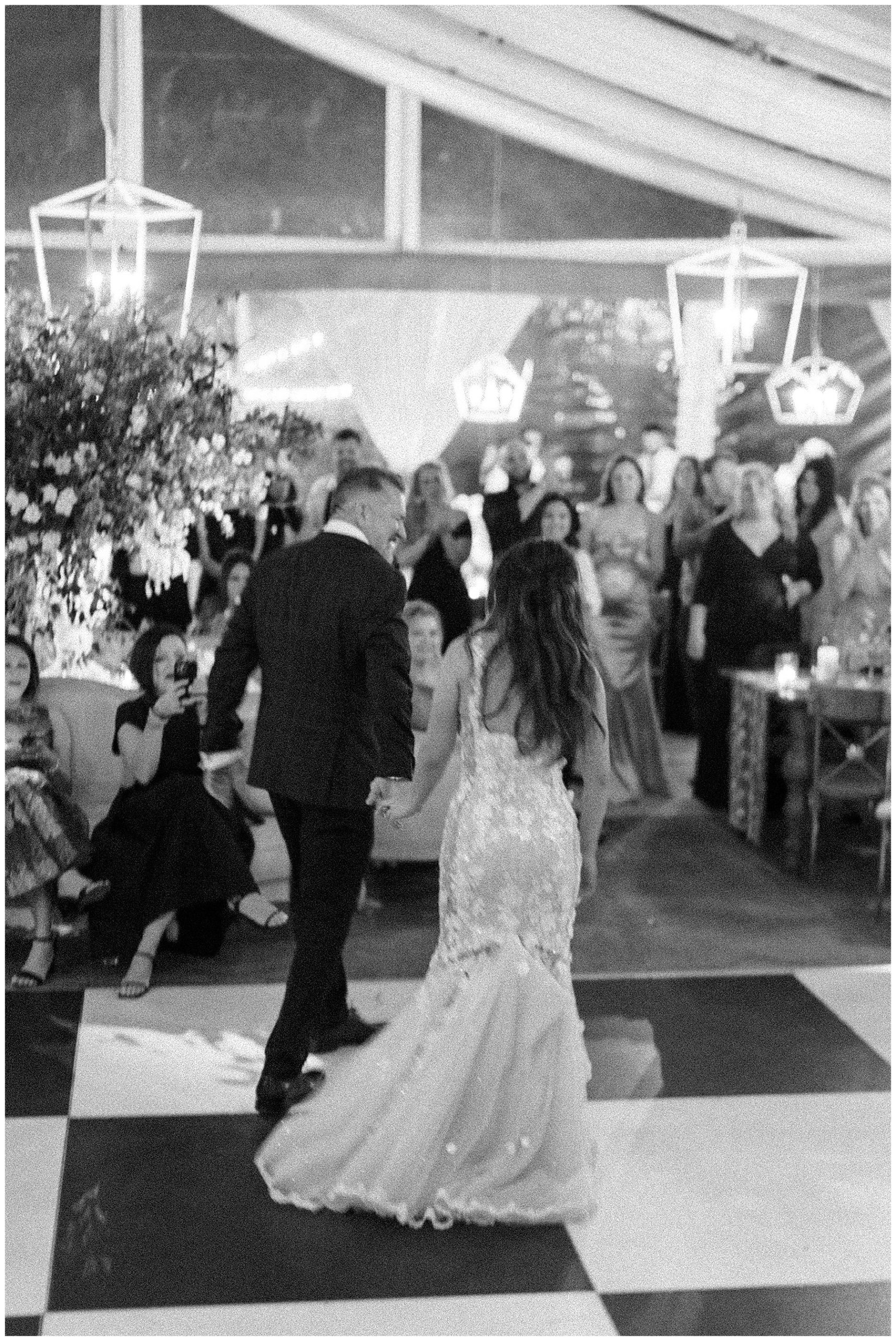 grainy black and white photo of couple walking on dance floor at Lowndes Grove