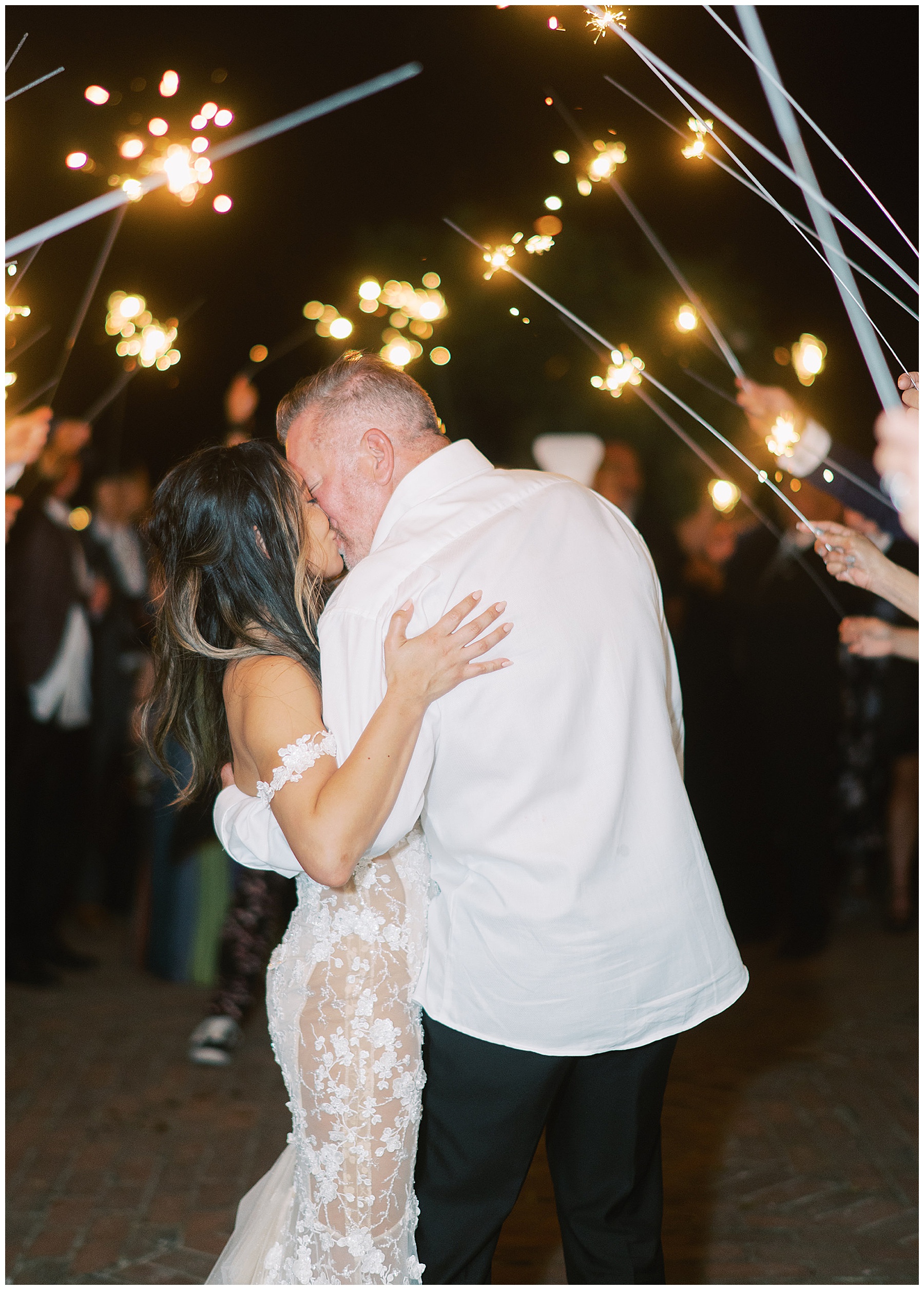 bride and groom kiss during sparkler exit after springtime wedding at Lowndes Grove