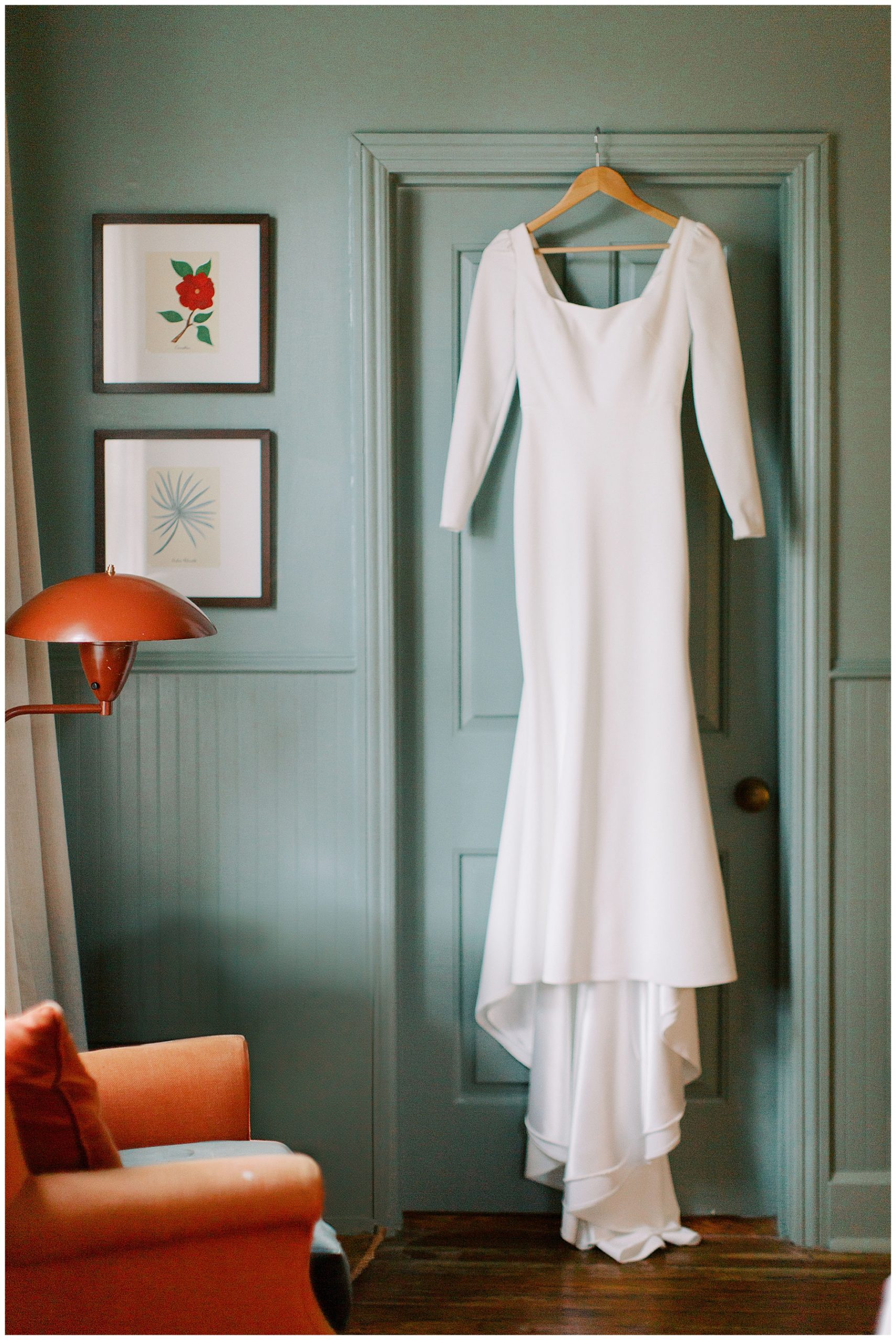 long sleeve wedding gown hangs on pale green doorframe inside the Post House Inn