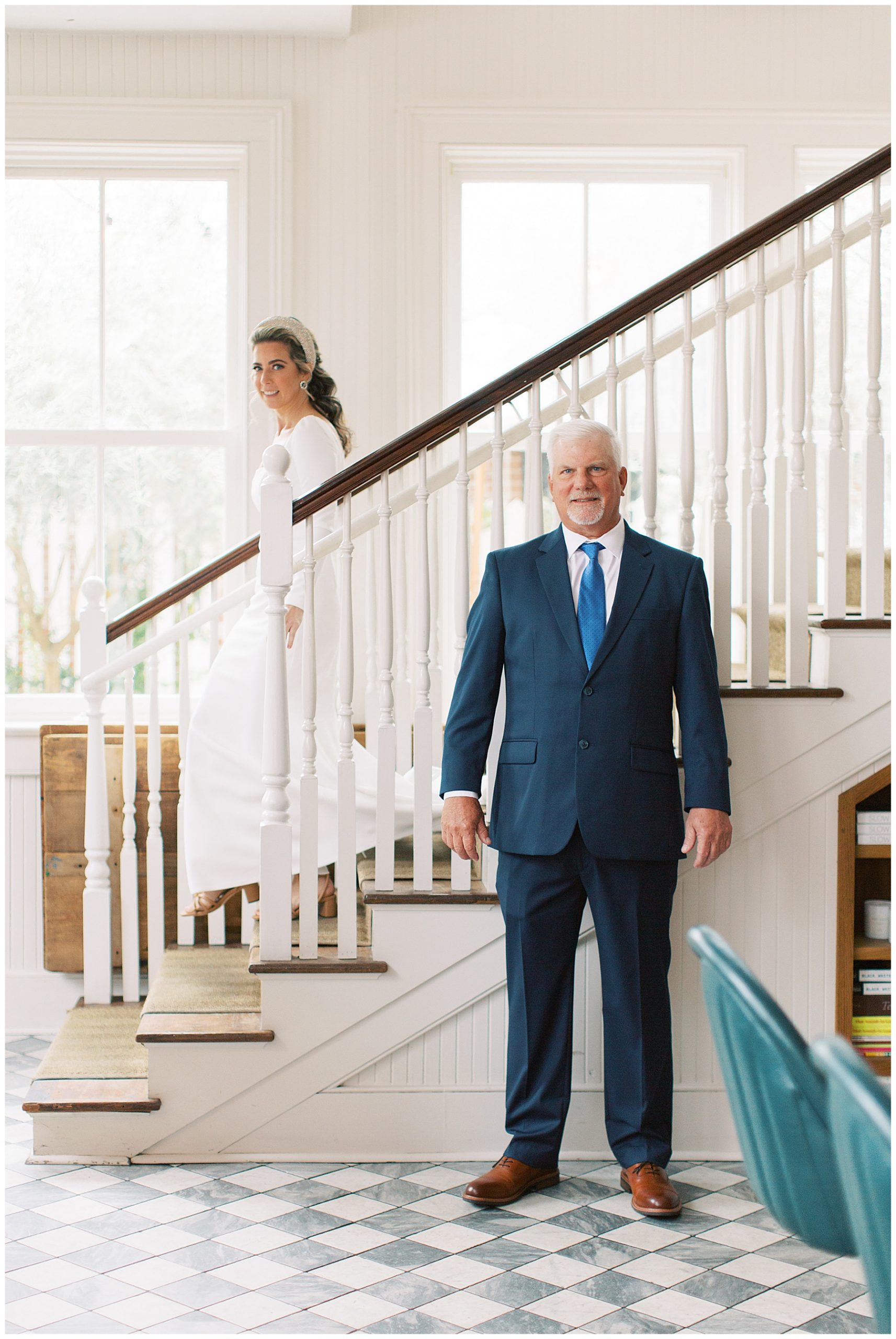 dad waits in front of staircase for bride to walk down for first look inside Charleston inn 