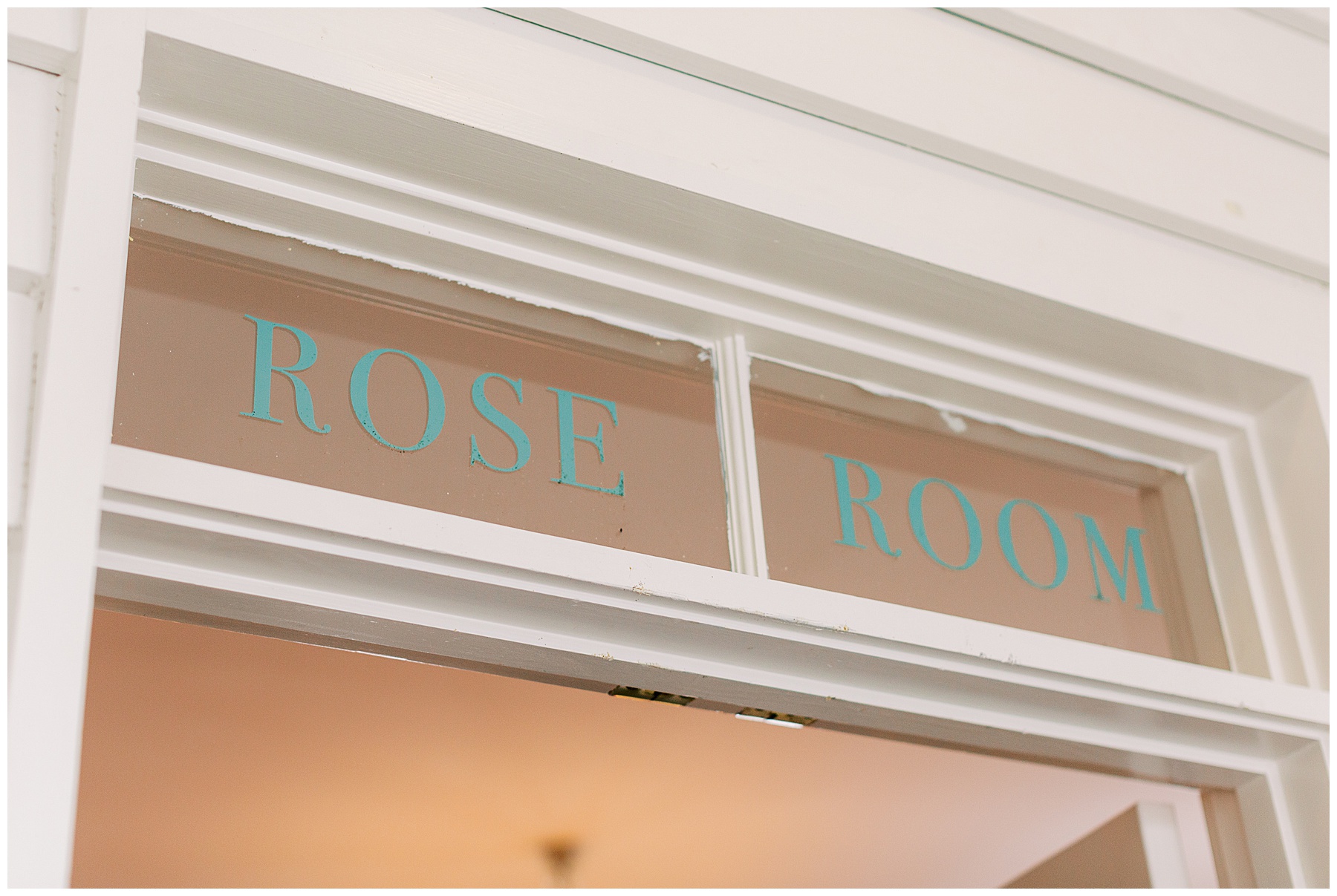 teal letters on glass window above door say "Rose Room" at the Post House Inn 