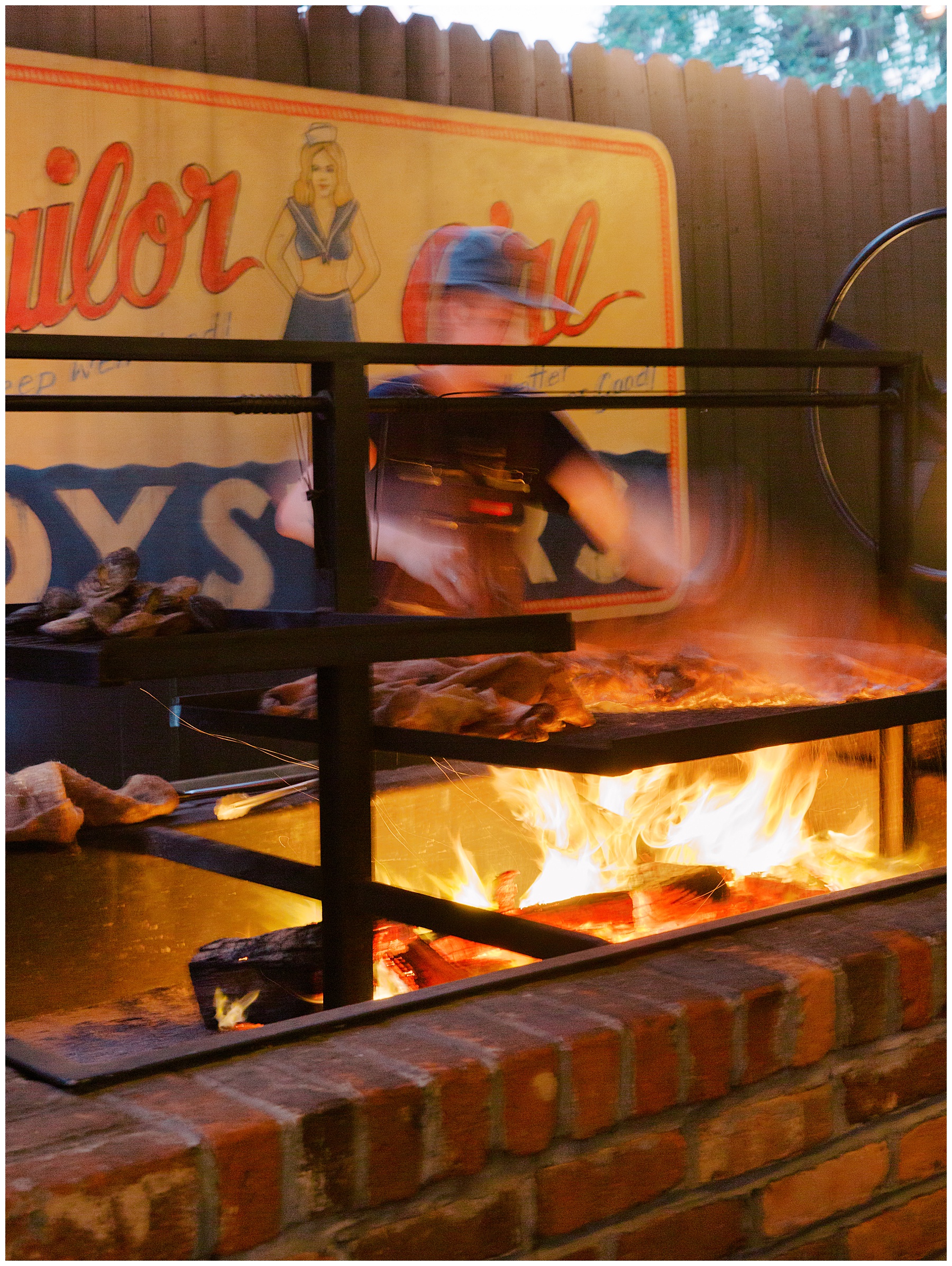 man works over BBQ grill outside Leon's Poultry & Oysters in Charleston SC