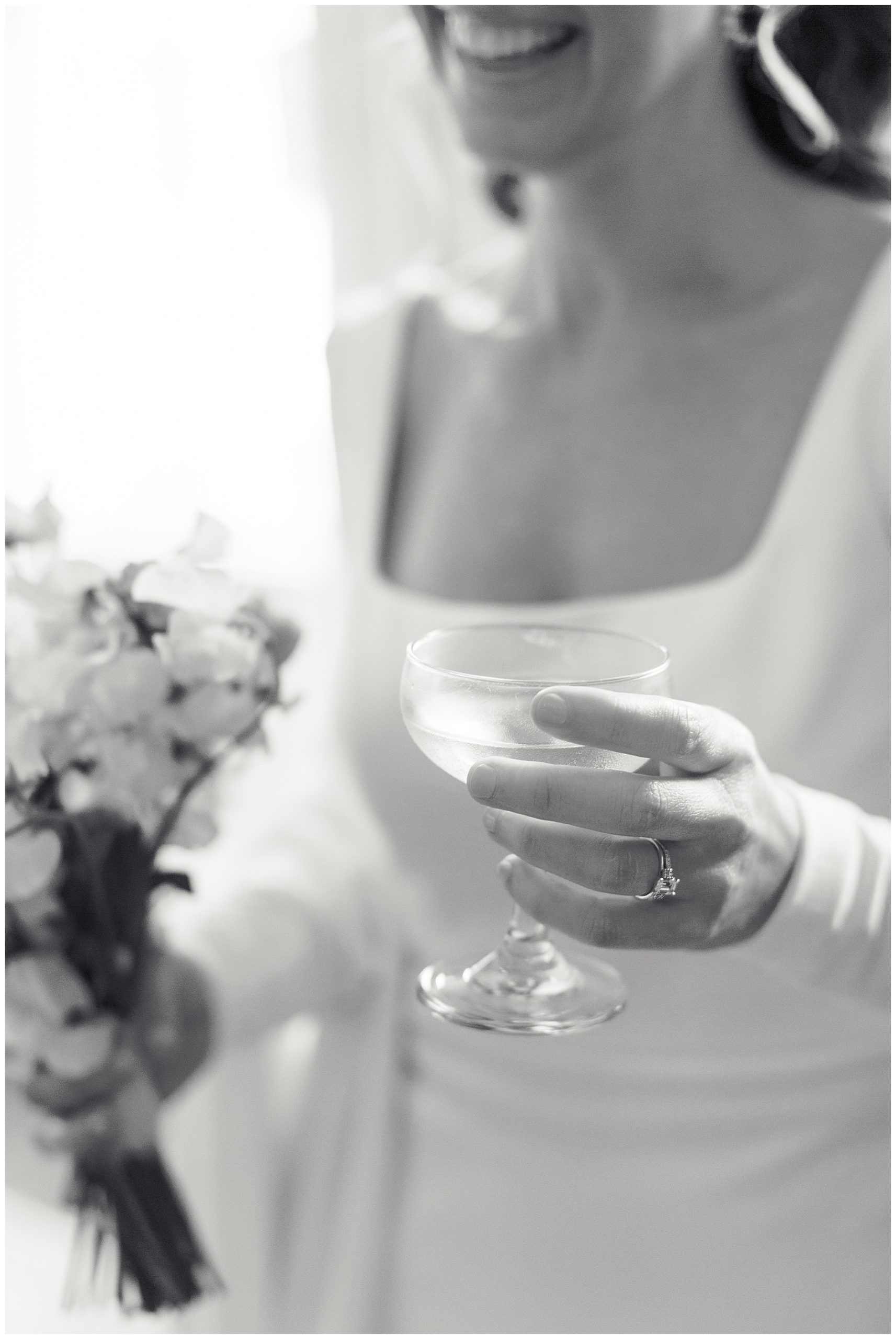 bride holds glass of champagne in long sleeve wedding gown 