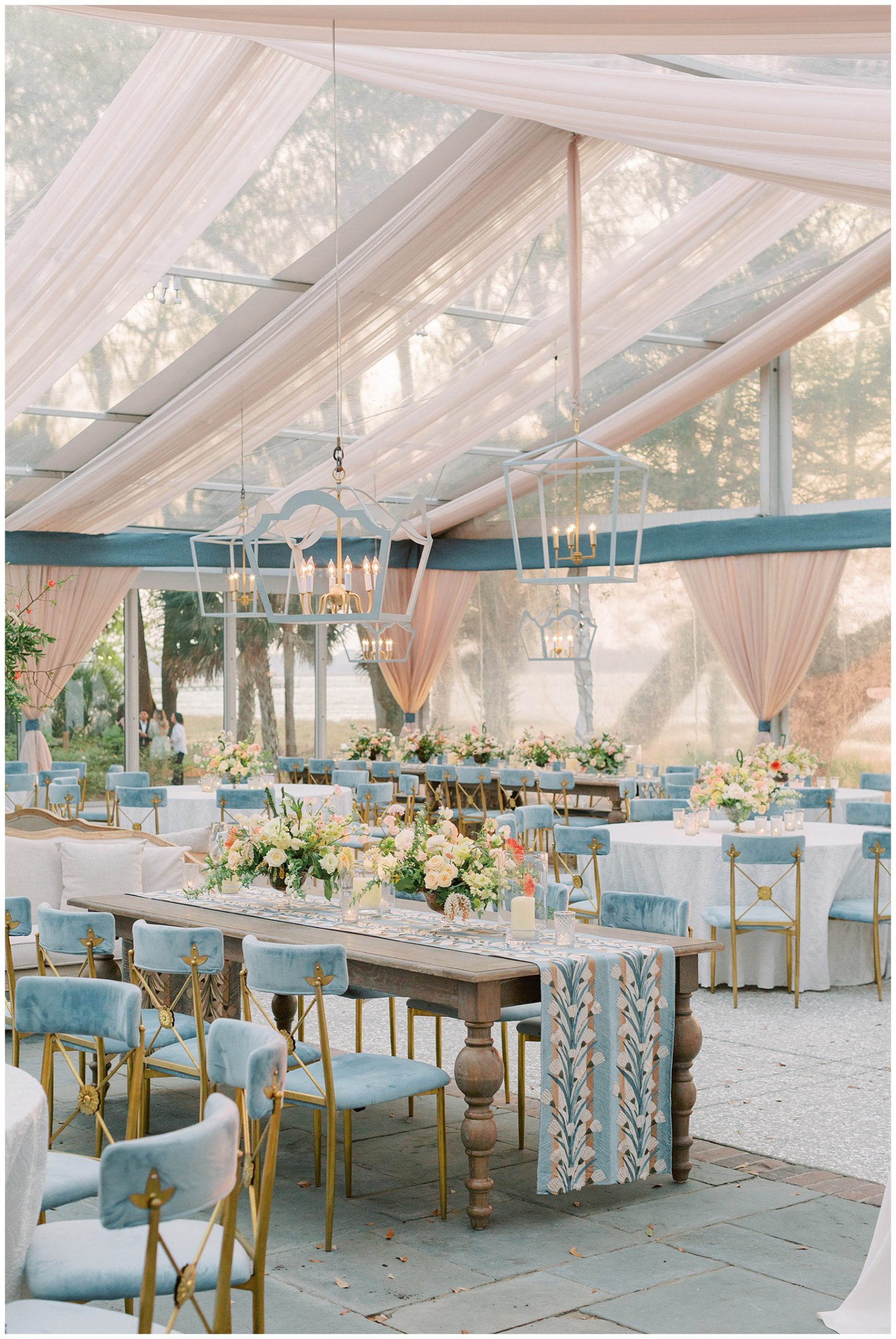 springtime wedding reception at Lowndes Grove with blue and gold chairs, spring flowers, and table runners 