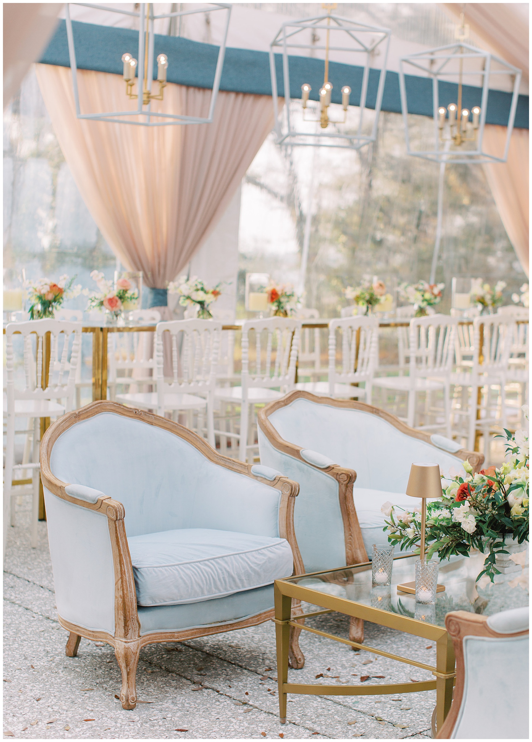 blue and gold chairs for seating area under clear tent at Lowndes Grove with hanging lanterns 