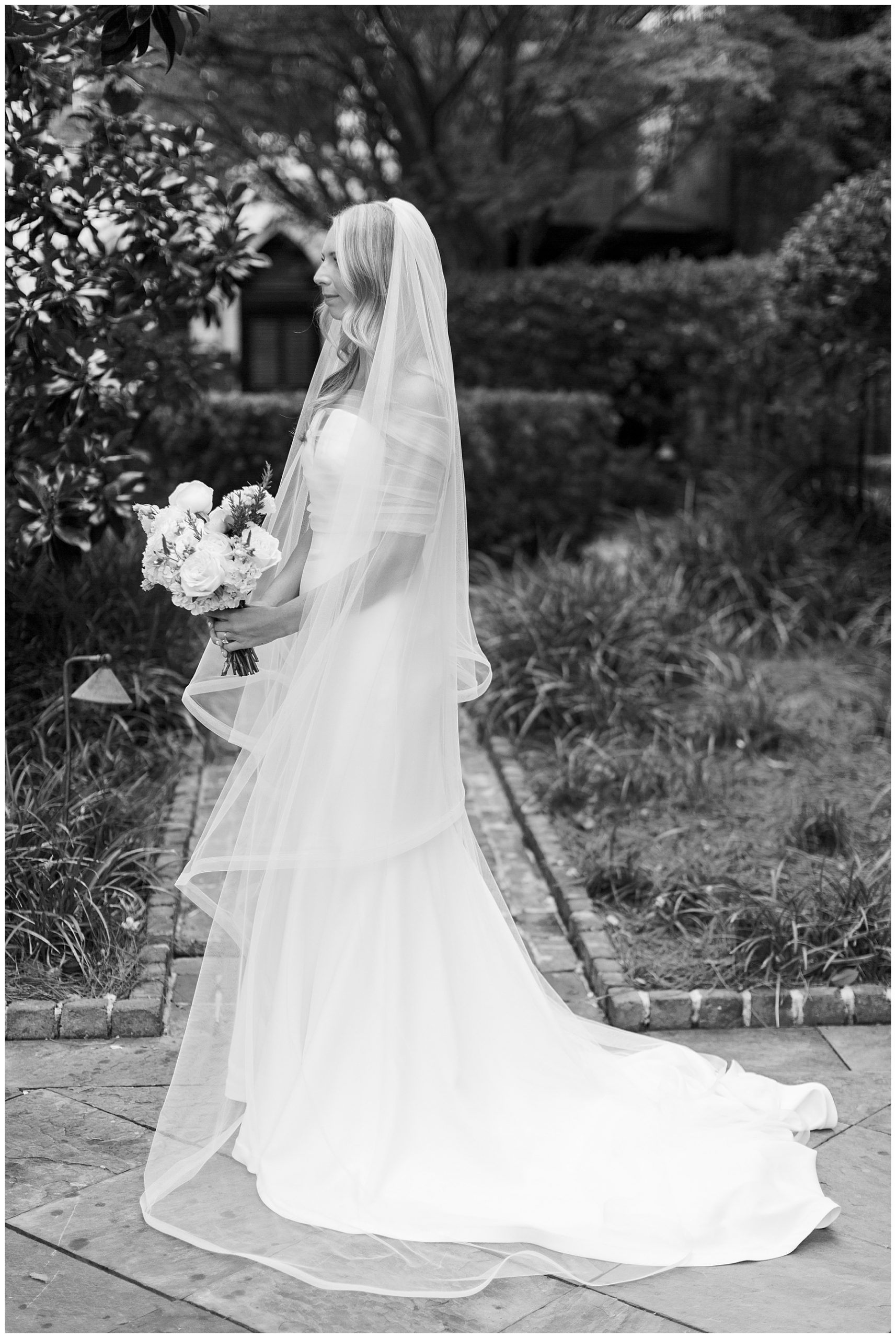 black and white photo of bride in gardens of the William Aiken House