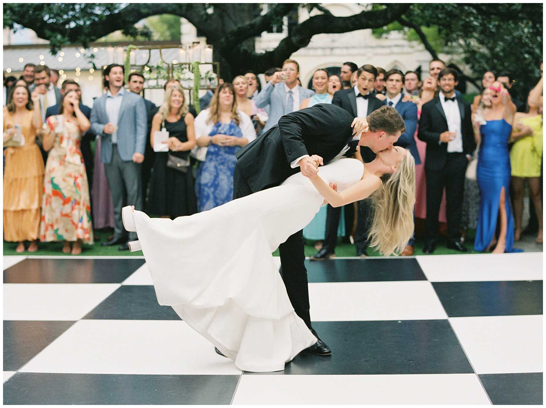 groom dips bride kissing her on the dance floor at the William Aiken House