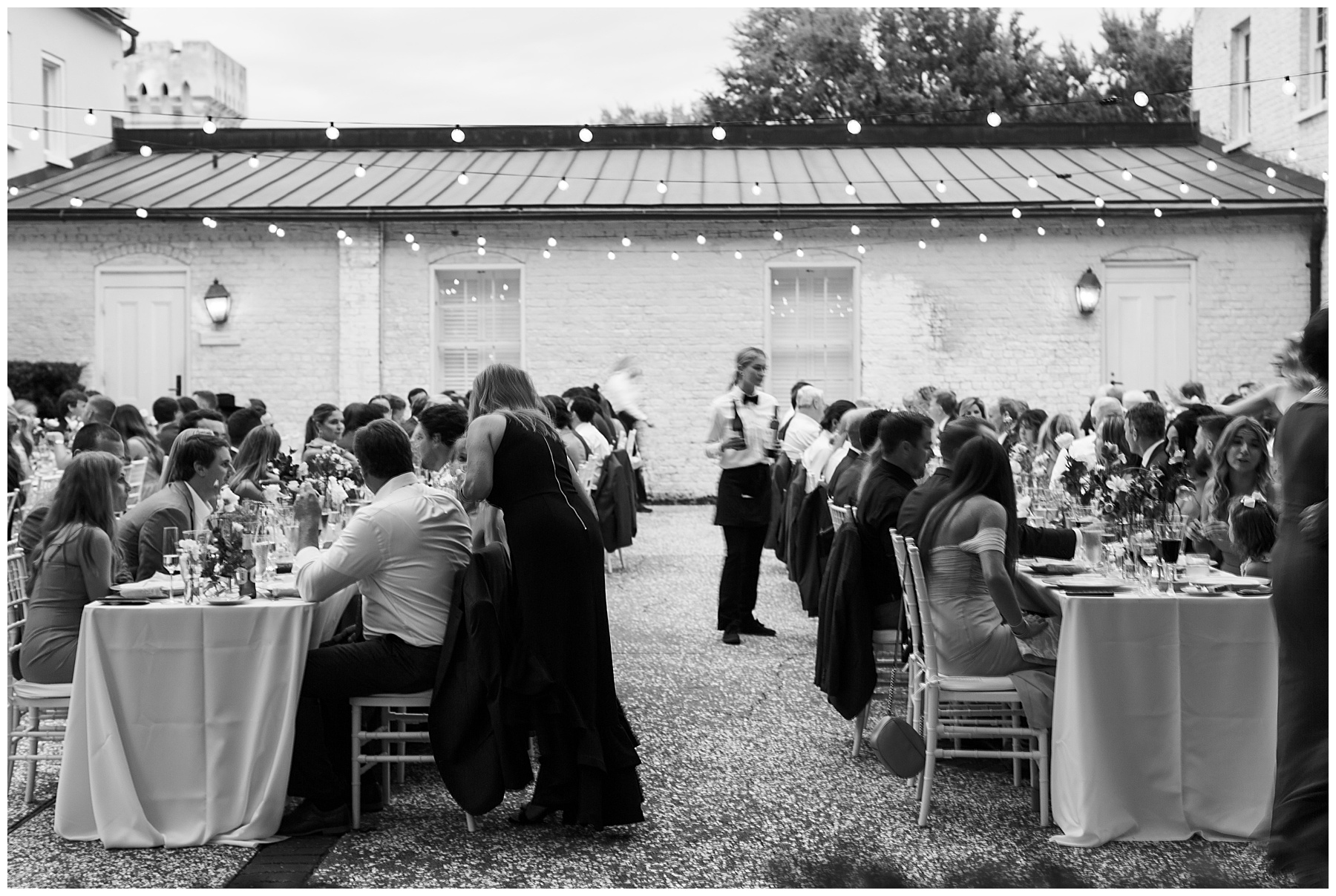 waiters serve guests on gravel patio at the William Aiken House