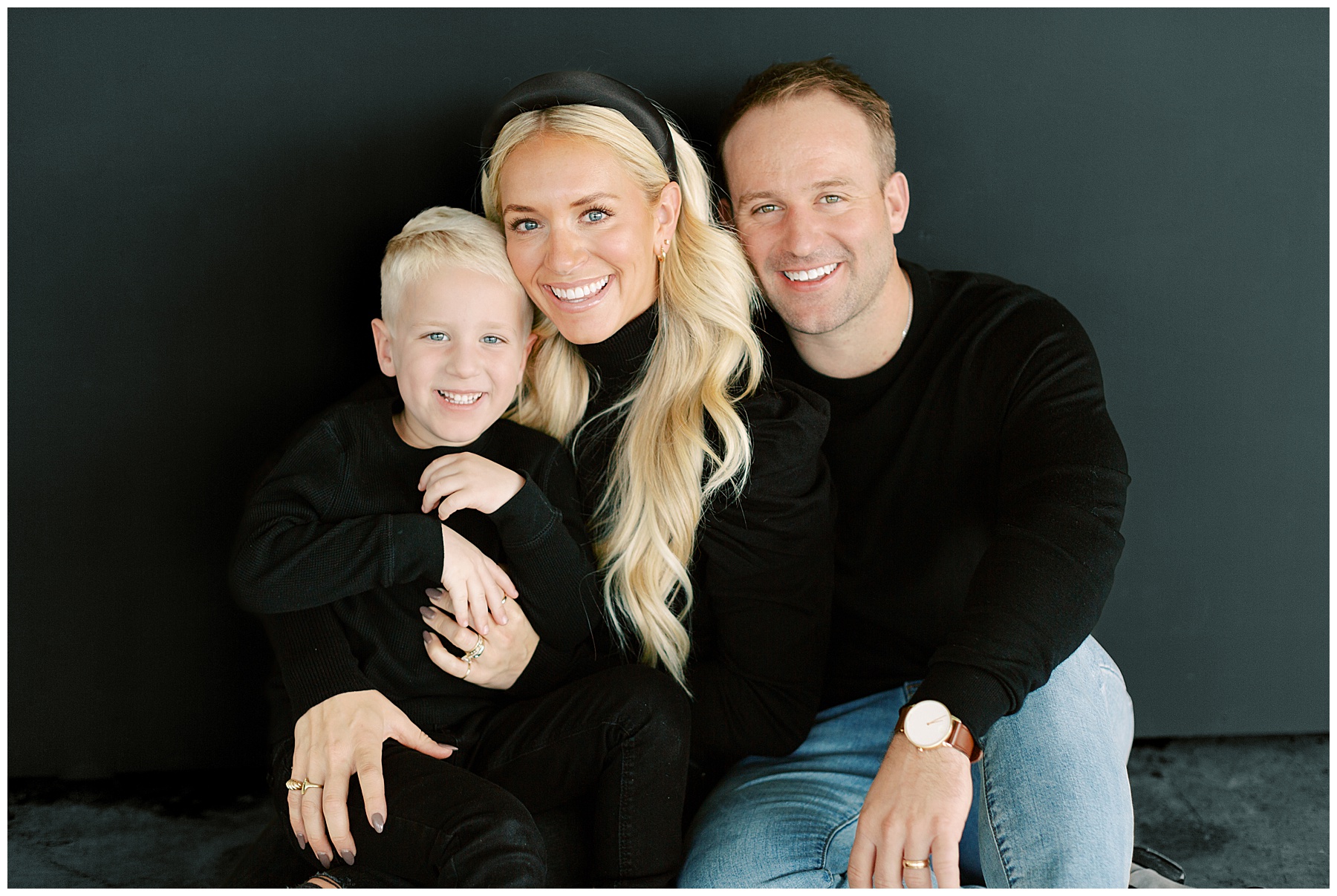 mom and dad snuggle holding son next to them during Charlotte studio family session