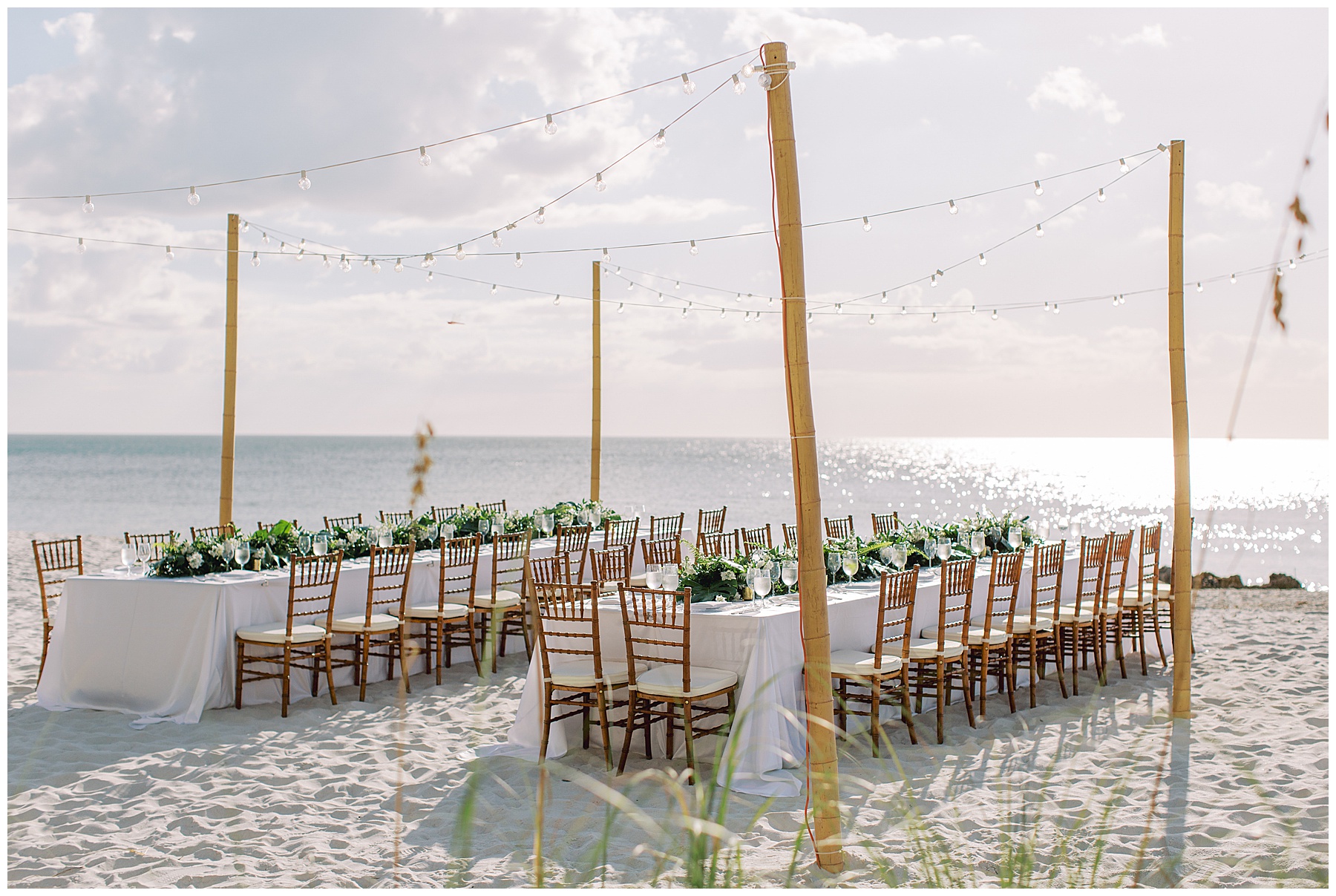 rehearsal dinner tables with lights hanging above on beach in Naples FL