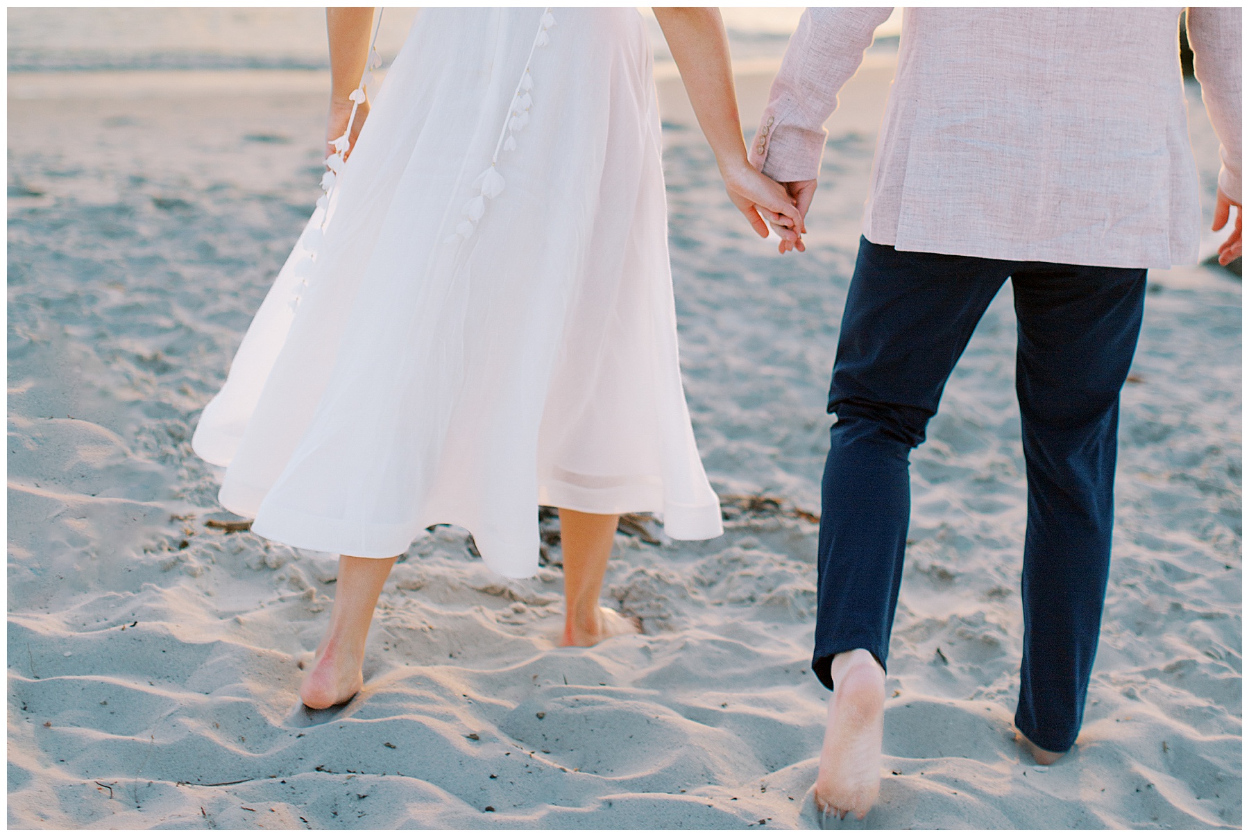 bride and groom hold hands walking on sand in Naples FL