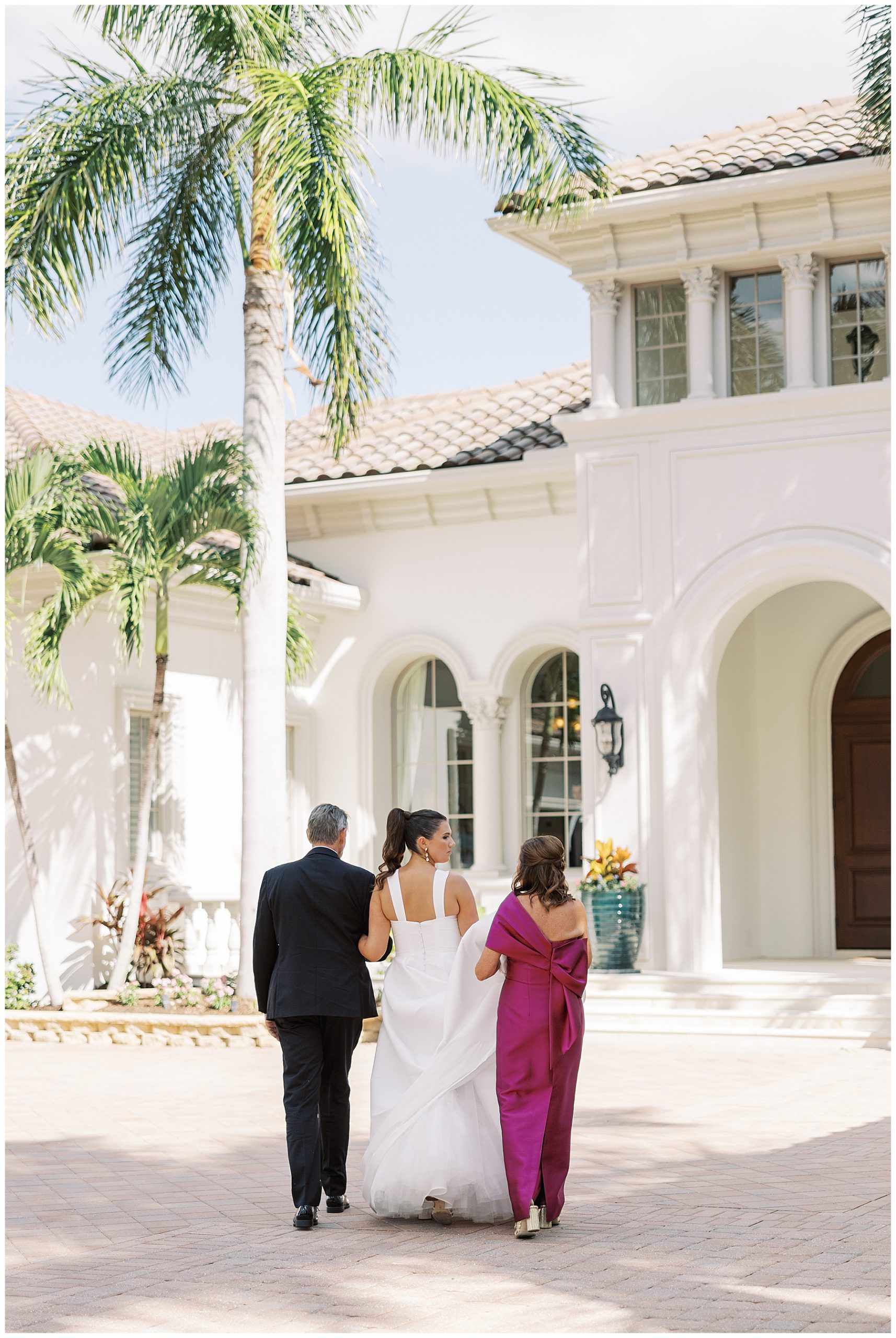 parents walk with bride across patio at Grey Oaks Country Club