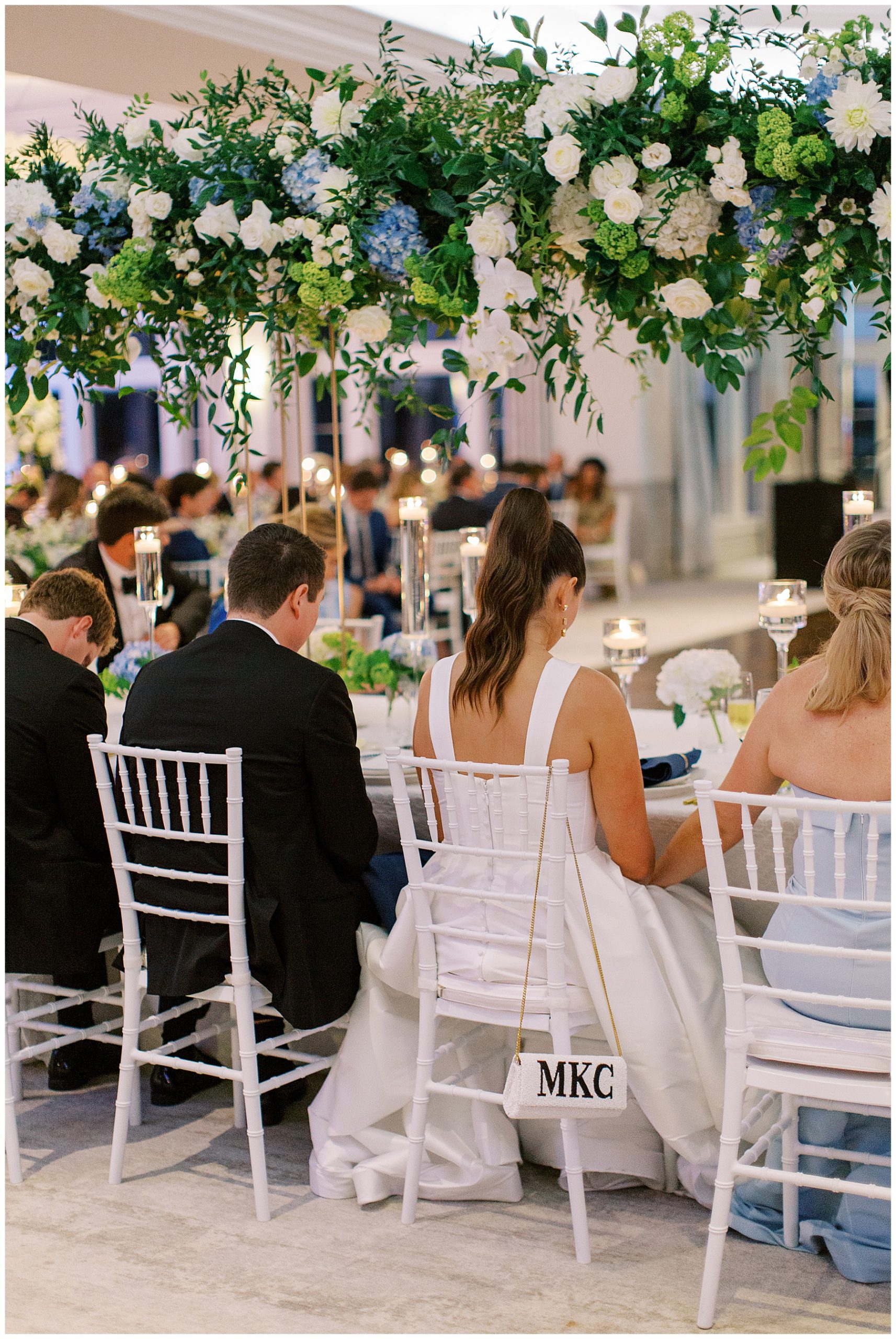 bride and groom pray with wedding guests during reception at Grey Oaks Country Club