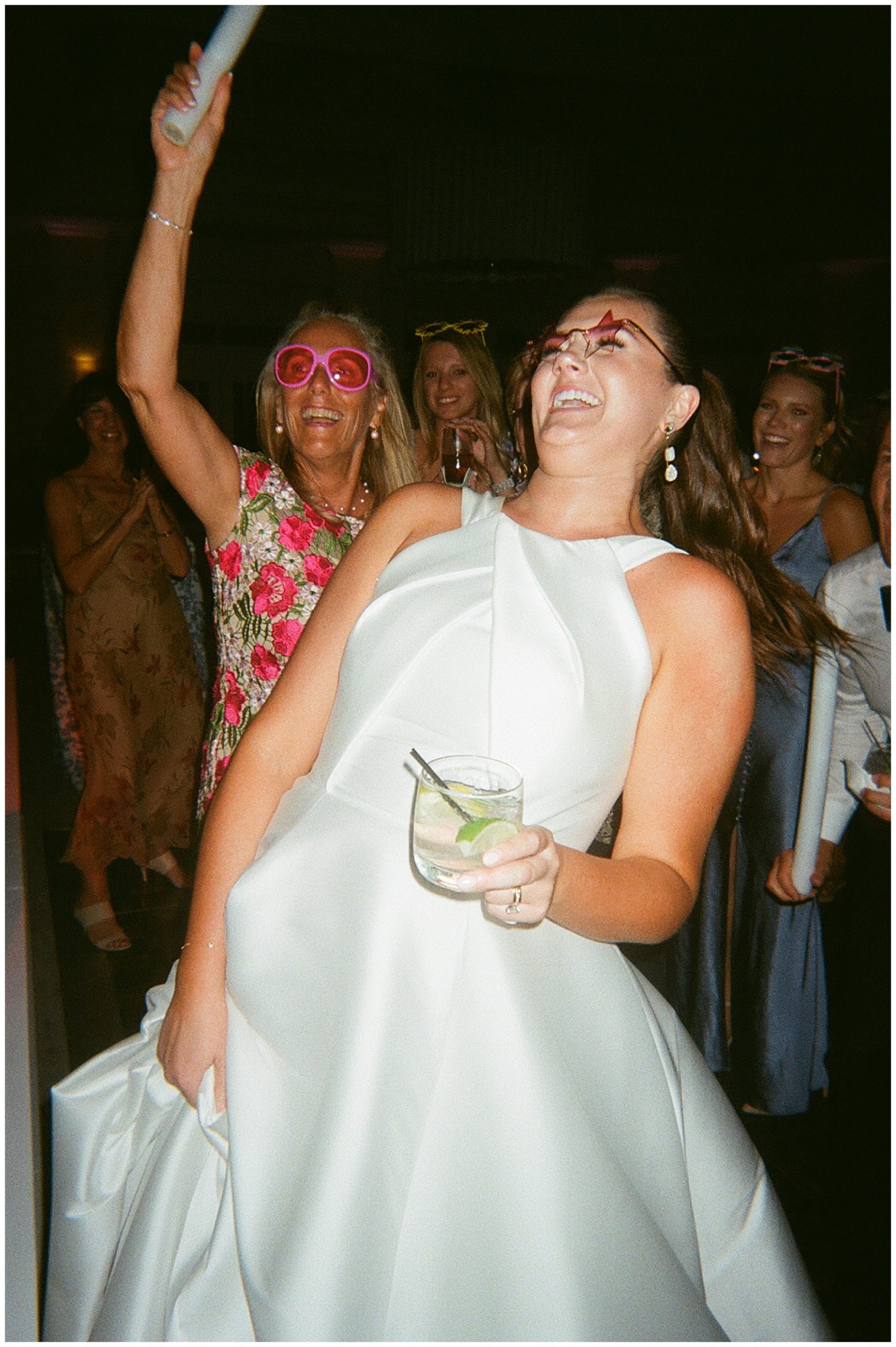 bride dances with silly sunglasses on dance floor during reception party 