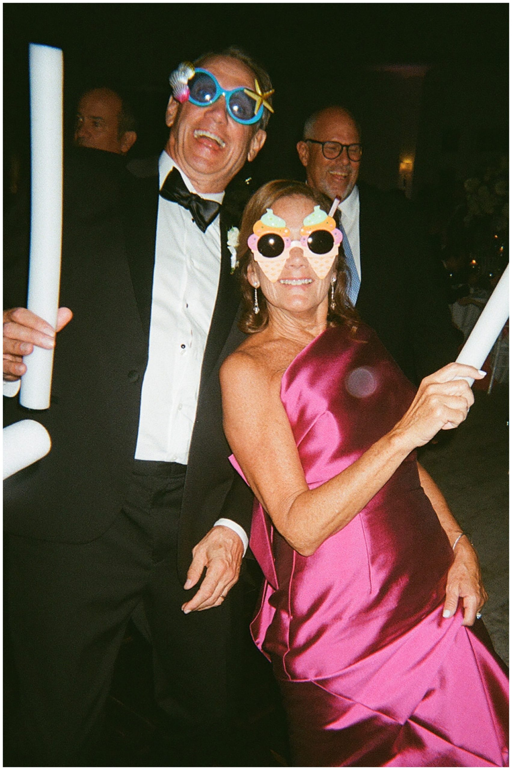 wedding guests dance with silly sunglasses and glow sticks at Grey Oaks Country Club