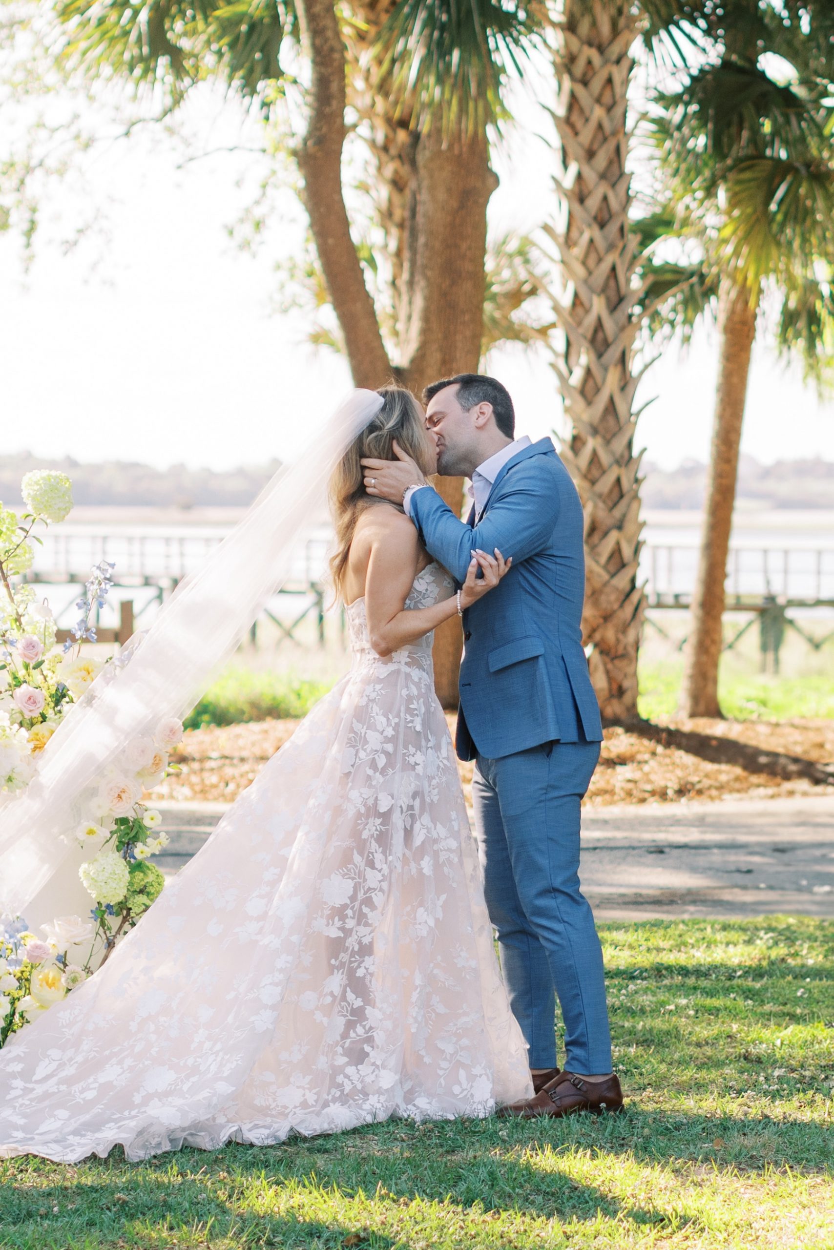 bride and groom kiss at outdoor wedding ceremony