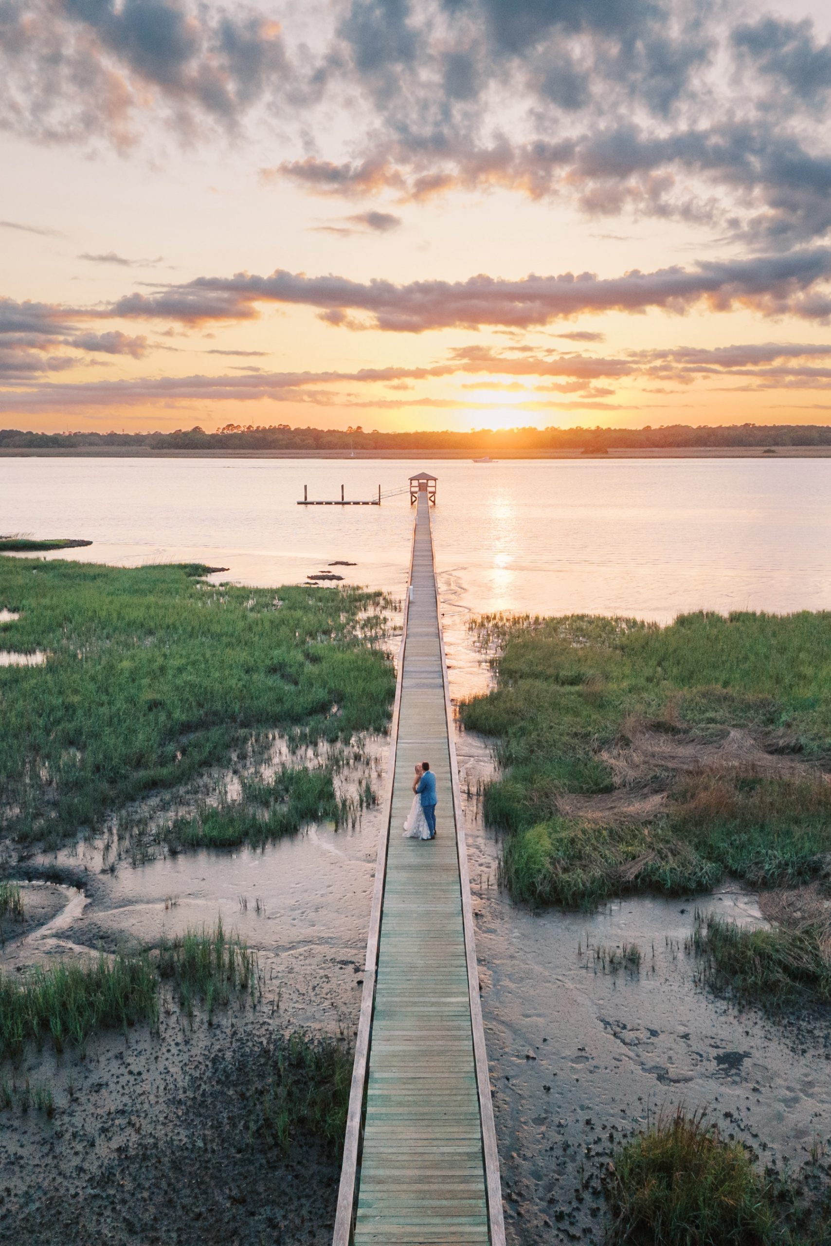 Charleston, SC wedding portraits at sunset with bride and groom on boardwalk leading to water
