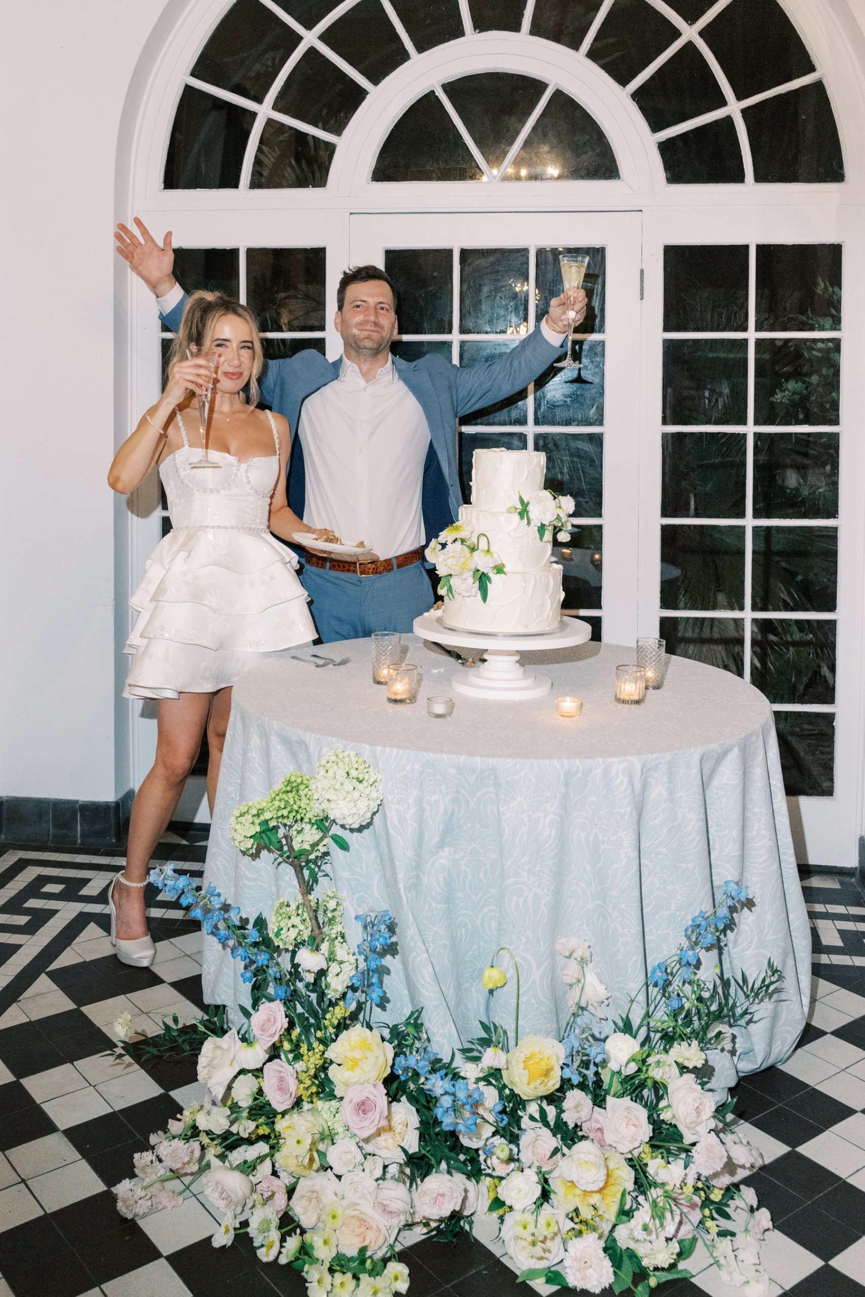 bride and groom by wedding cake