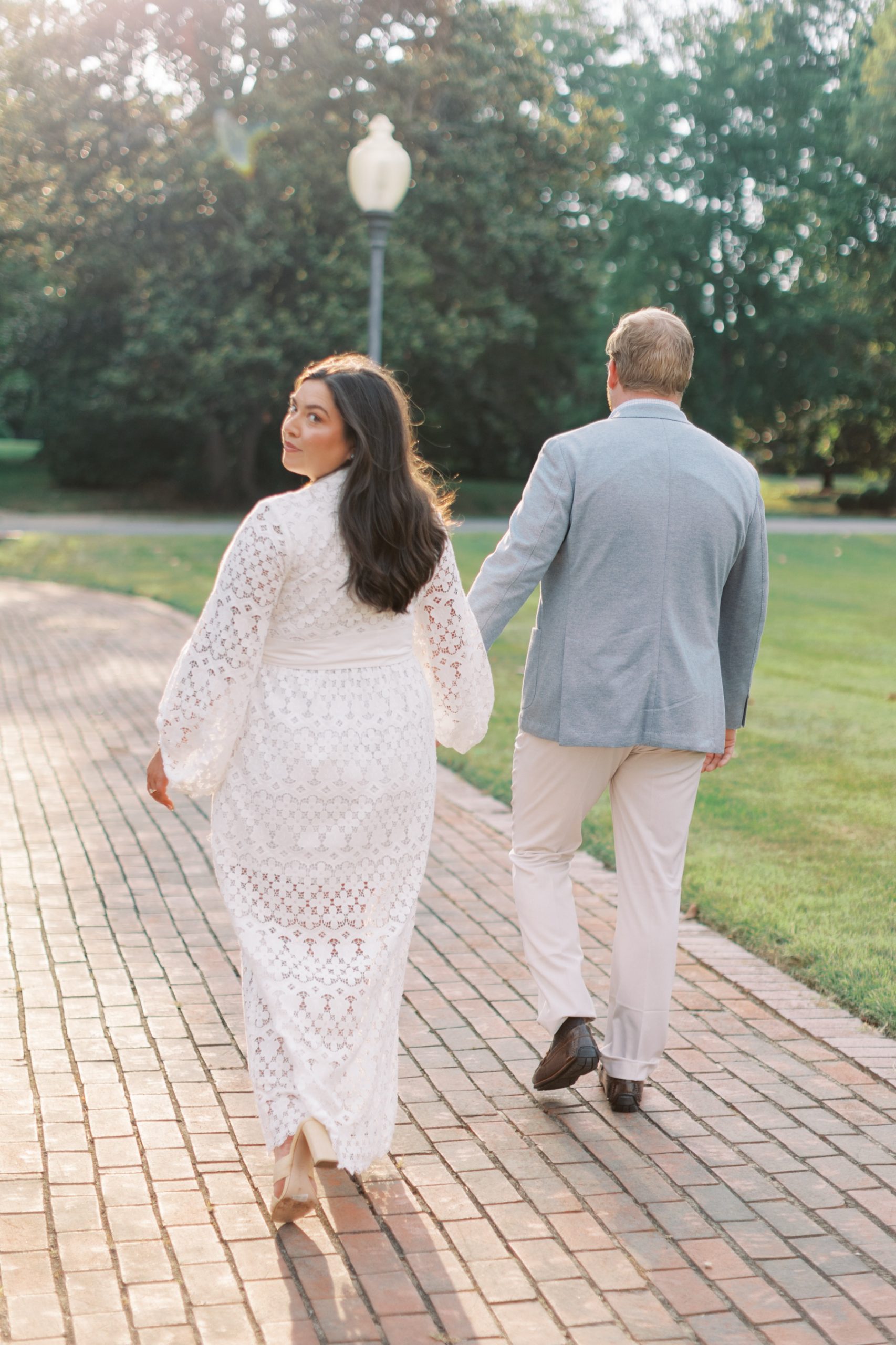 couple walk together holding hands during Elegant Engagement Session in Charlotte, NC 