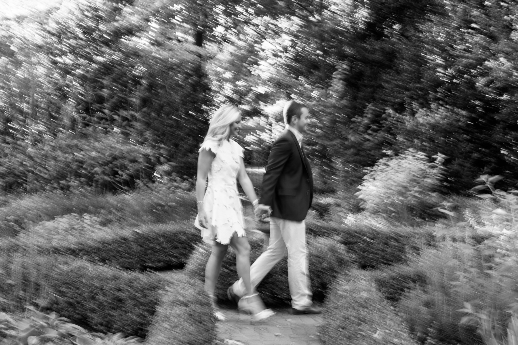 couple walk through Winghaven Gardens holdings hands