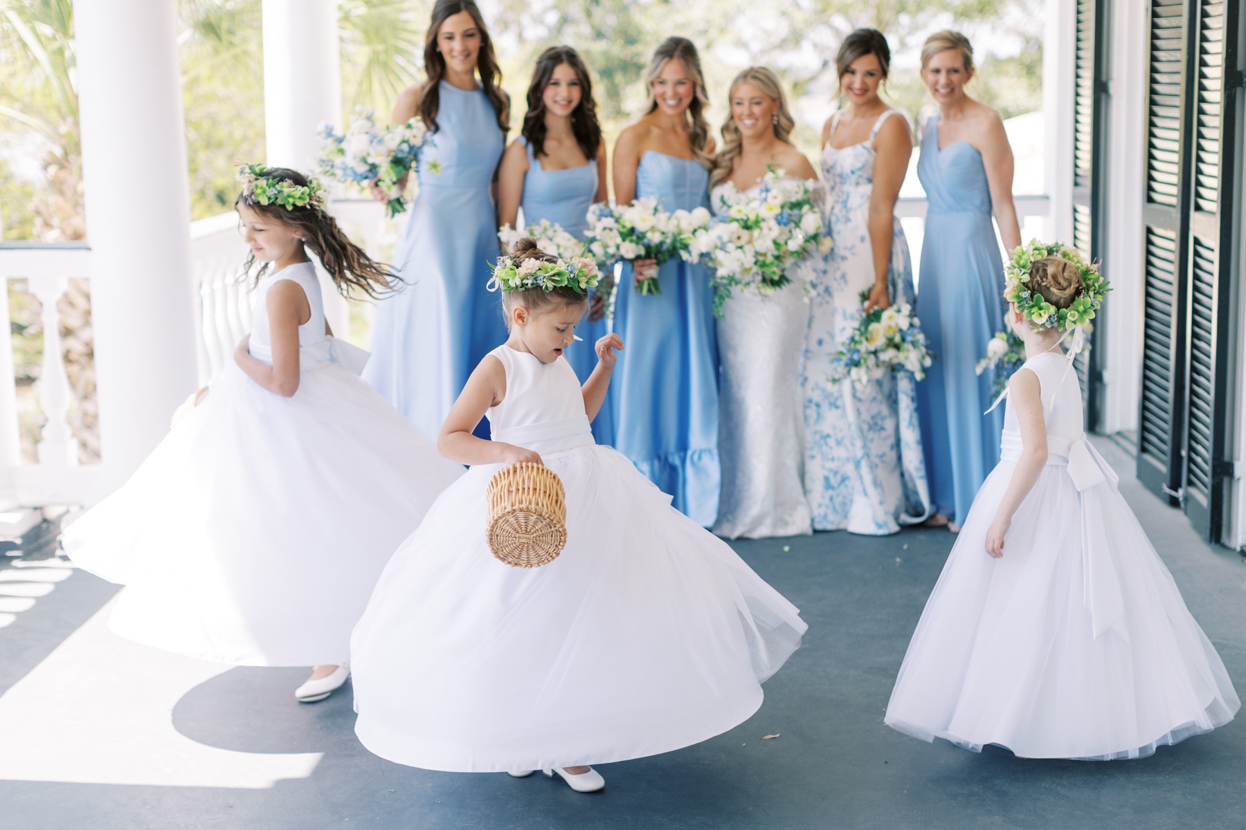 three flower girls twirl in front of bride and bridesmaids 