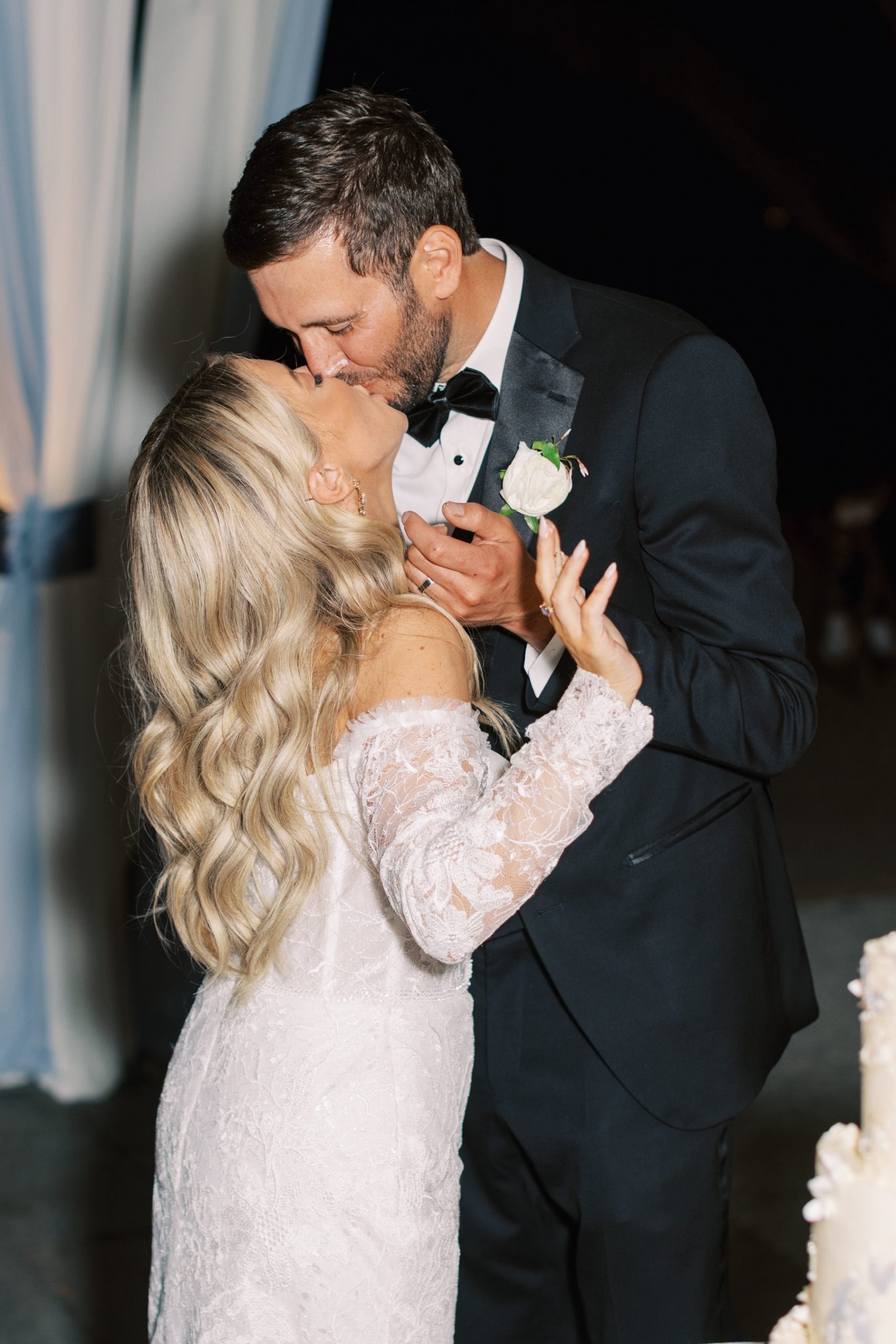 newlyweds kiss during cake cutting