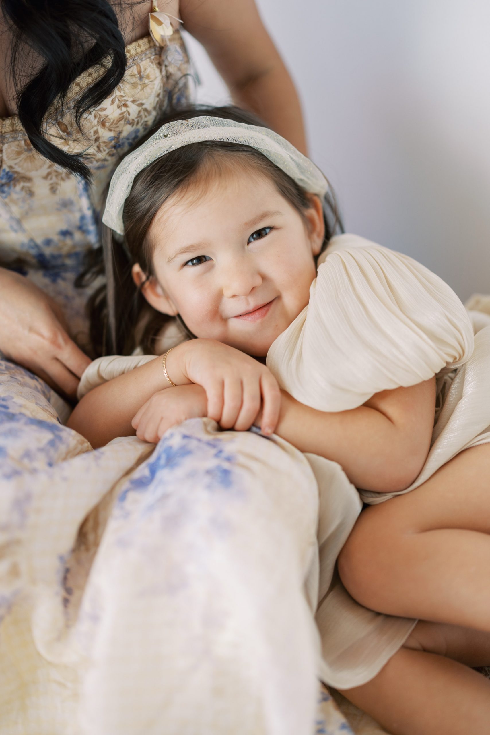 little girl lays on mother's lap