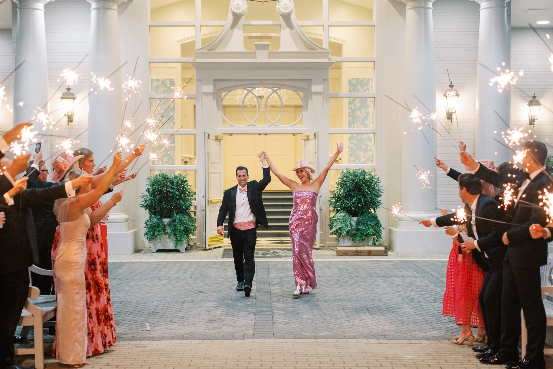 Newlyweds exit reception with guests holding sparklers