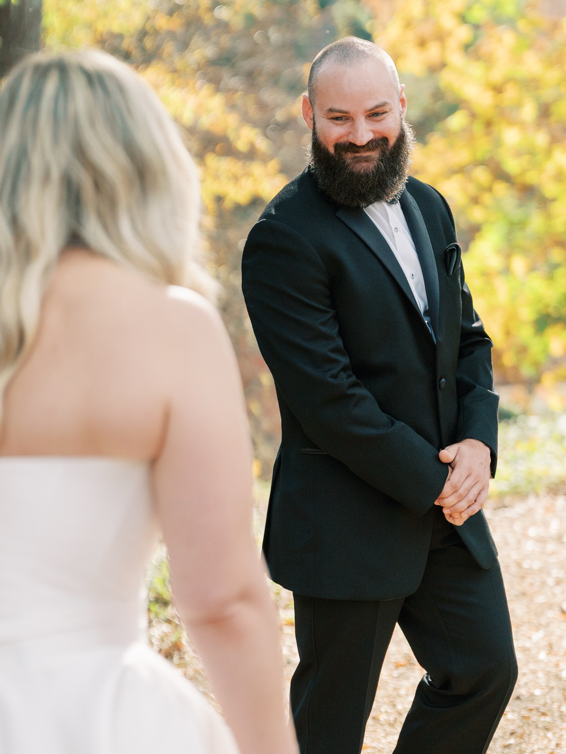 First look - bride from behind with groom facing her and smiling