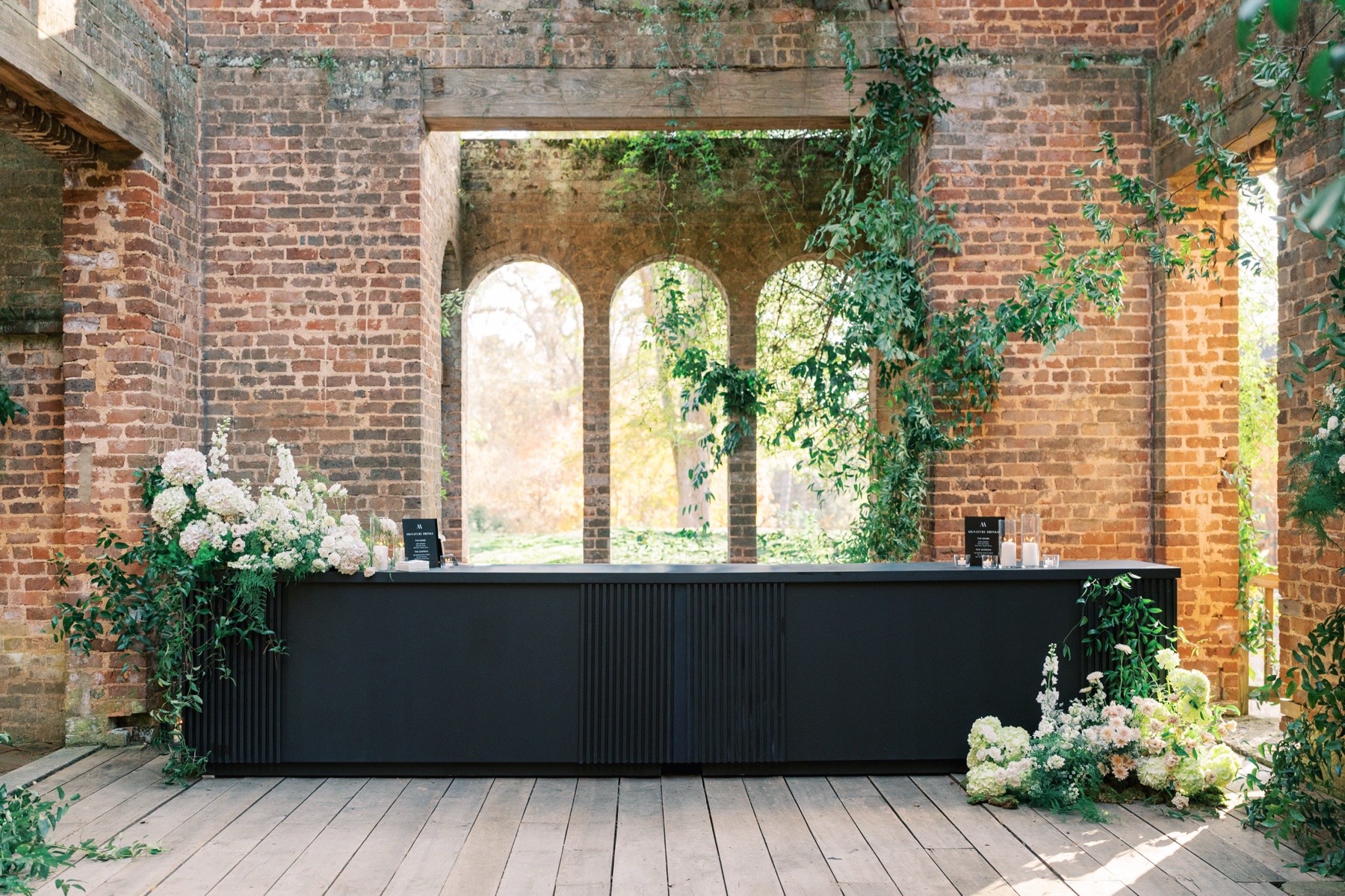 Long black bar table set up inside the brick building