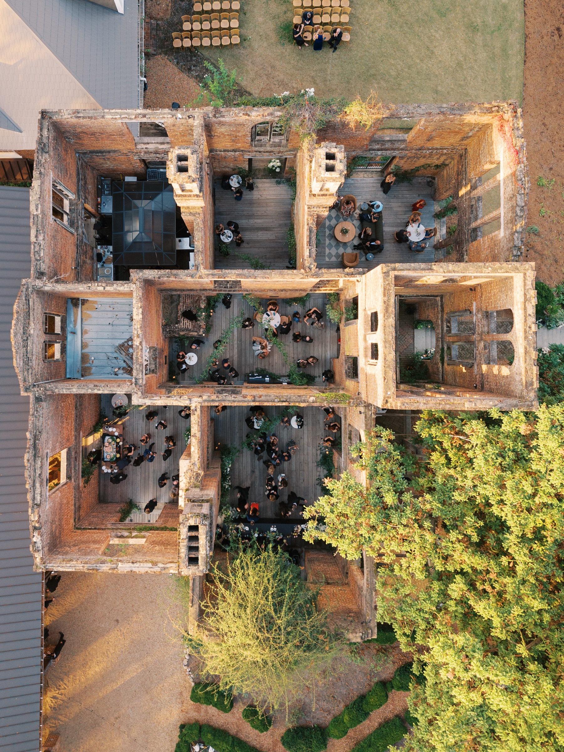 Overhead drone shot of the ruins with no roof but each room decorated and filled with guests for the Barnsley Resort Wedding