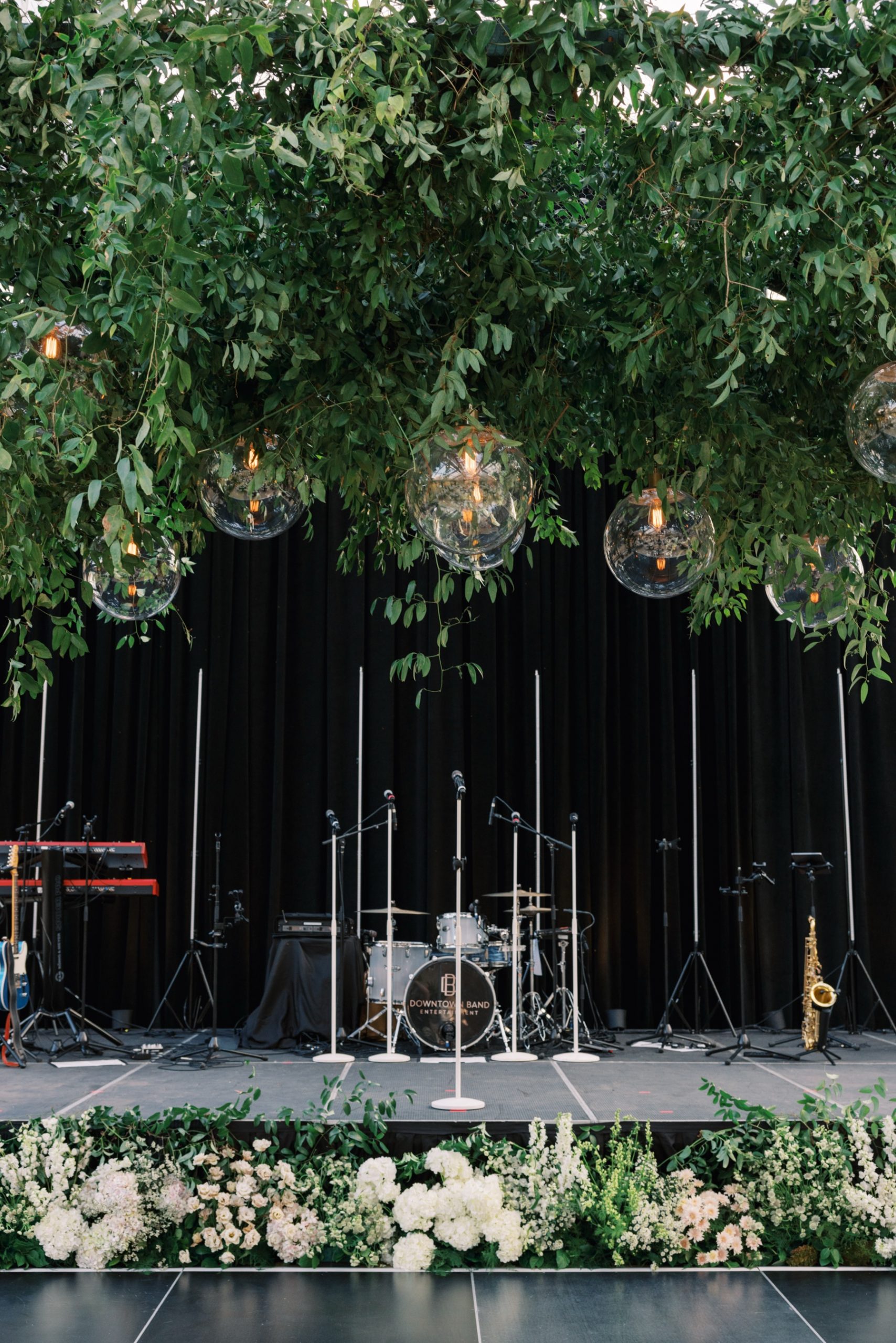 Stage area with instruments and greenery with glass ball lights hanging overhead