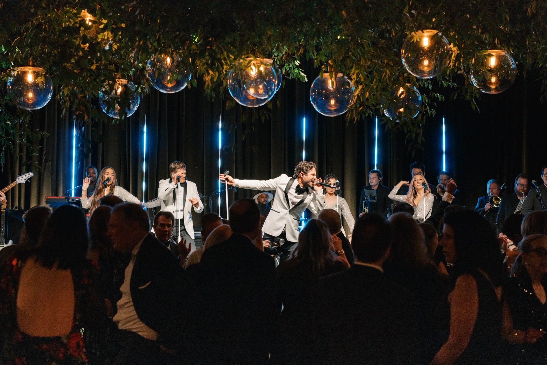 Singers in white jackets performing on the stage
