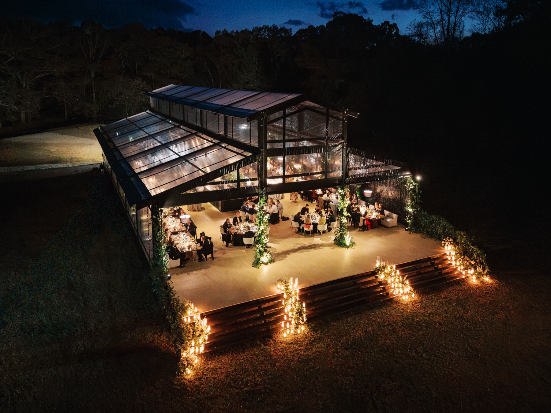 aerial shot of reception tent at night lit up with guests inside at a Barnsley Resort Wedding