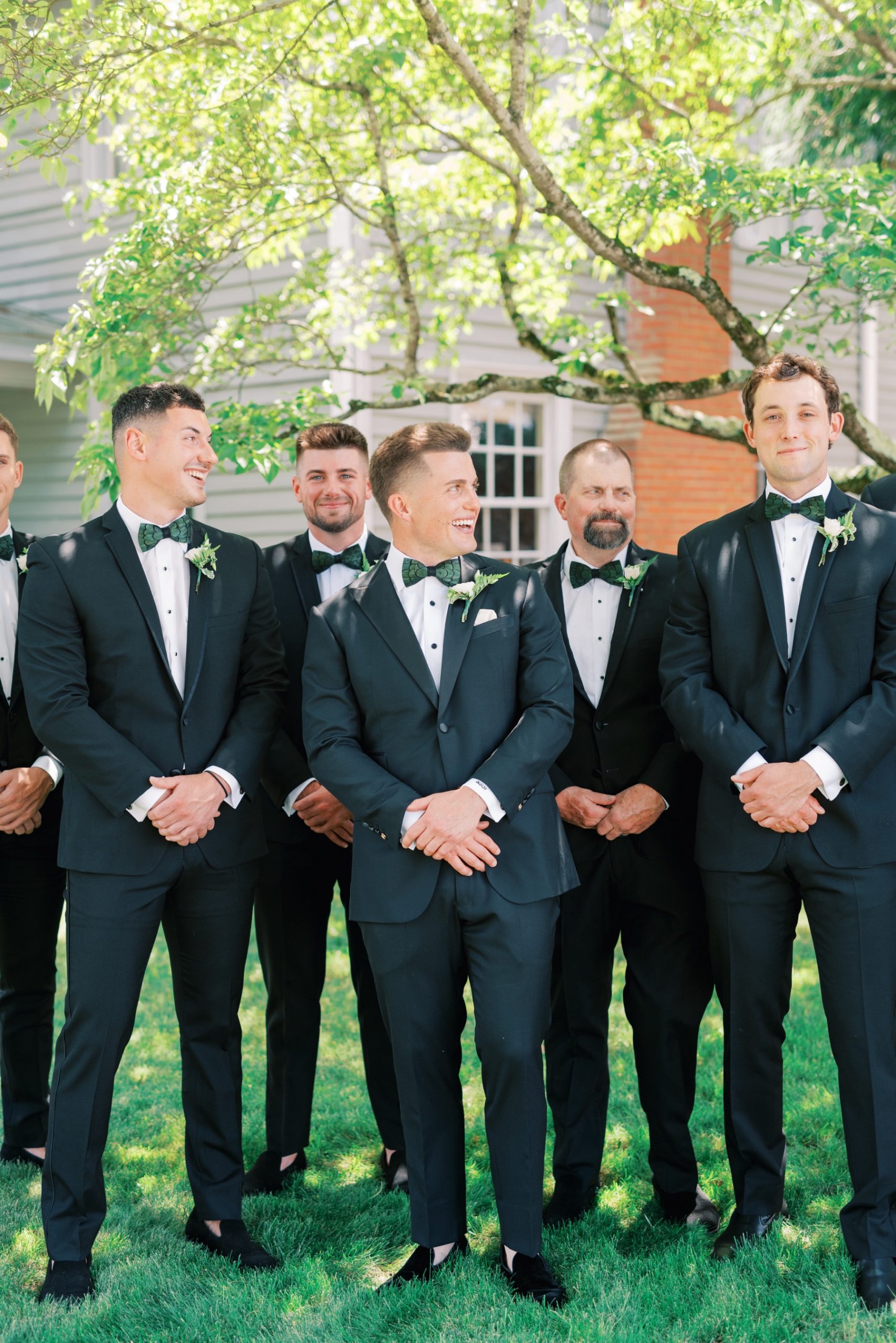 groom standing with his groomsmen wearing black tuxes and green bowties for a North Carolina Estate Wedding