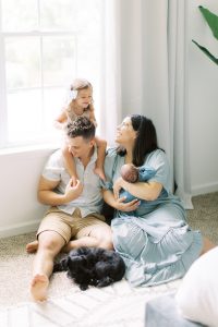family poses with dog during Charlotte lifestyle newborn session