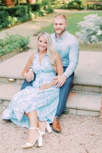 engaged couple sits on granite steps outside Duke Mansion