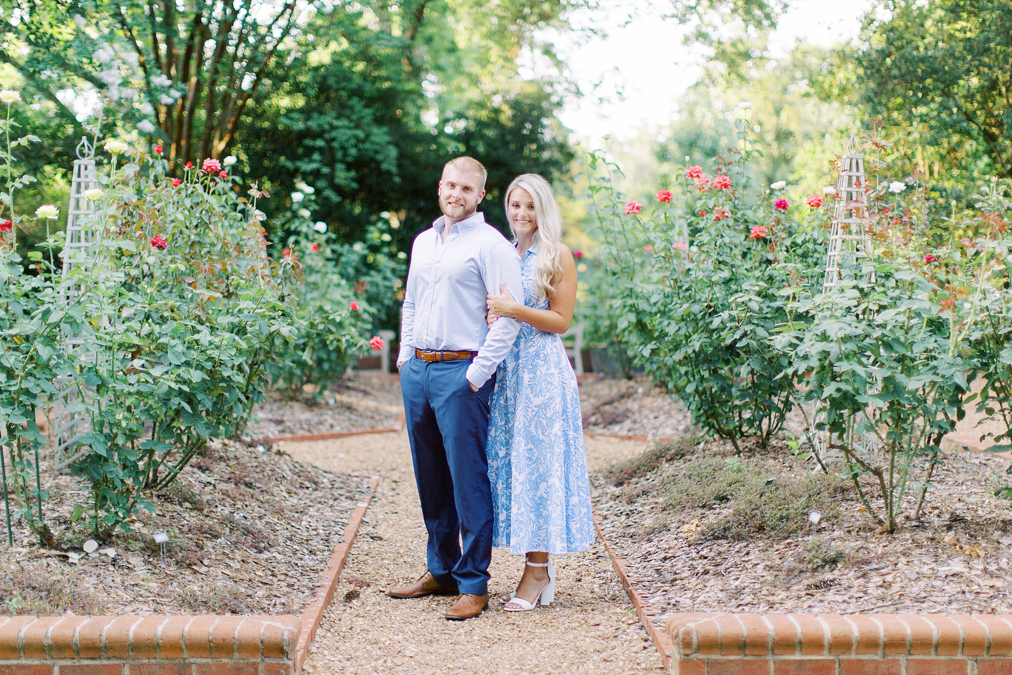 bride and groom pose in gardens of Duke Mansion during spring engagement photos