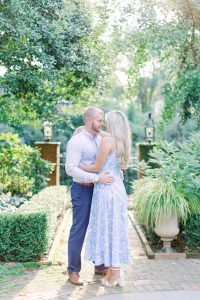 bride and groom pose in pathway of gardens of Charlotte NC mansion