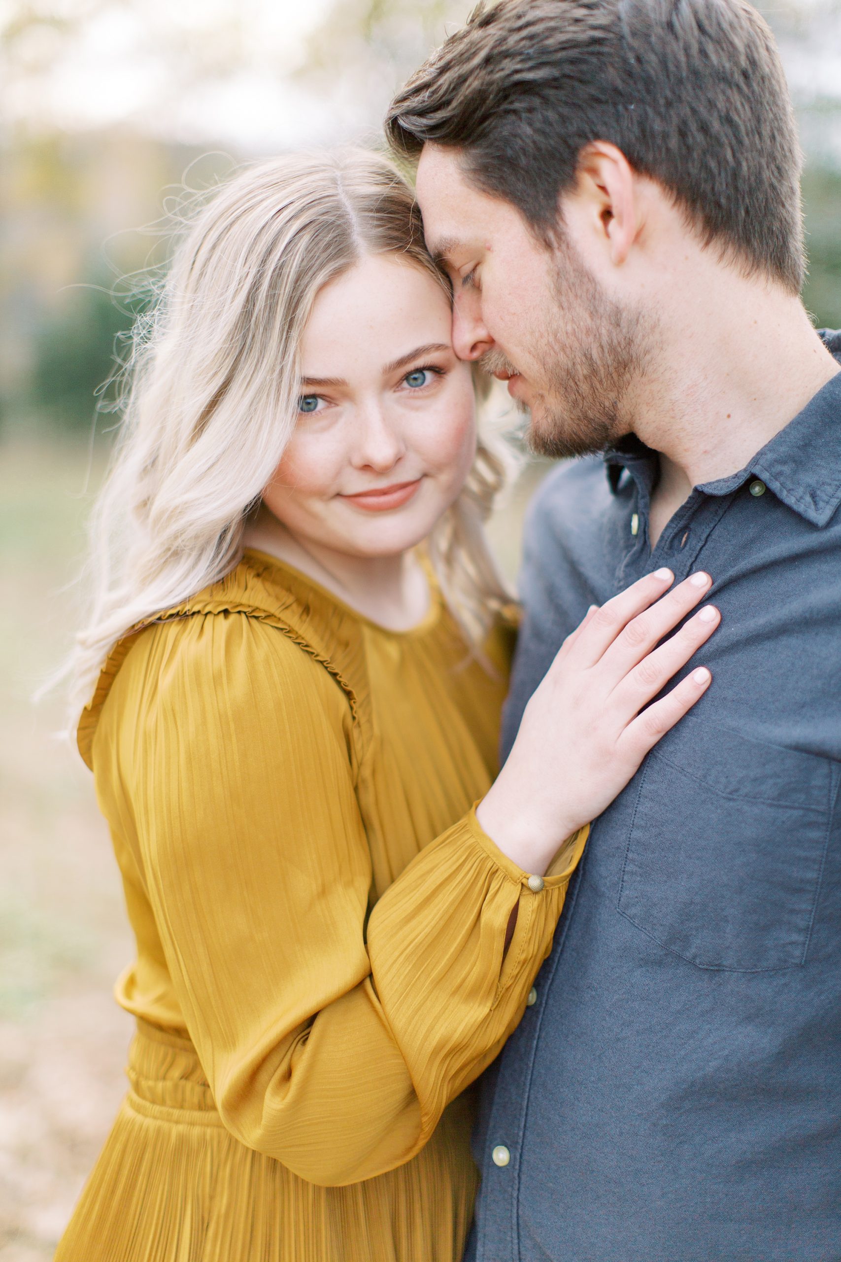 bride poses against groom's chest during North Corner Haven engagement photos