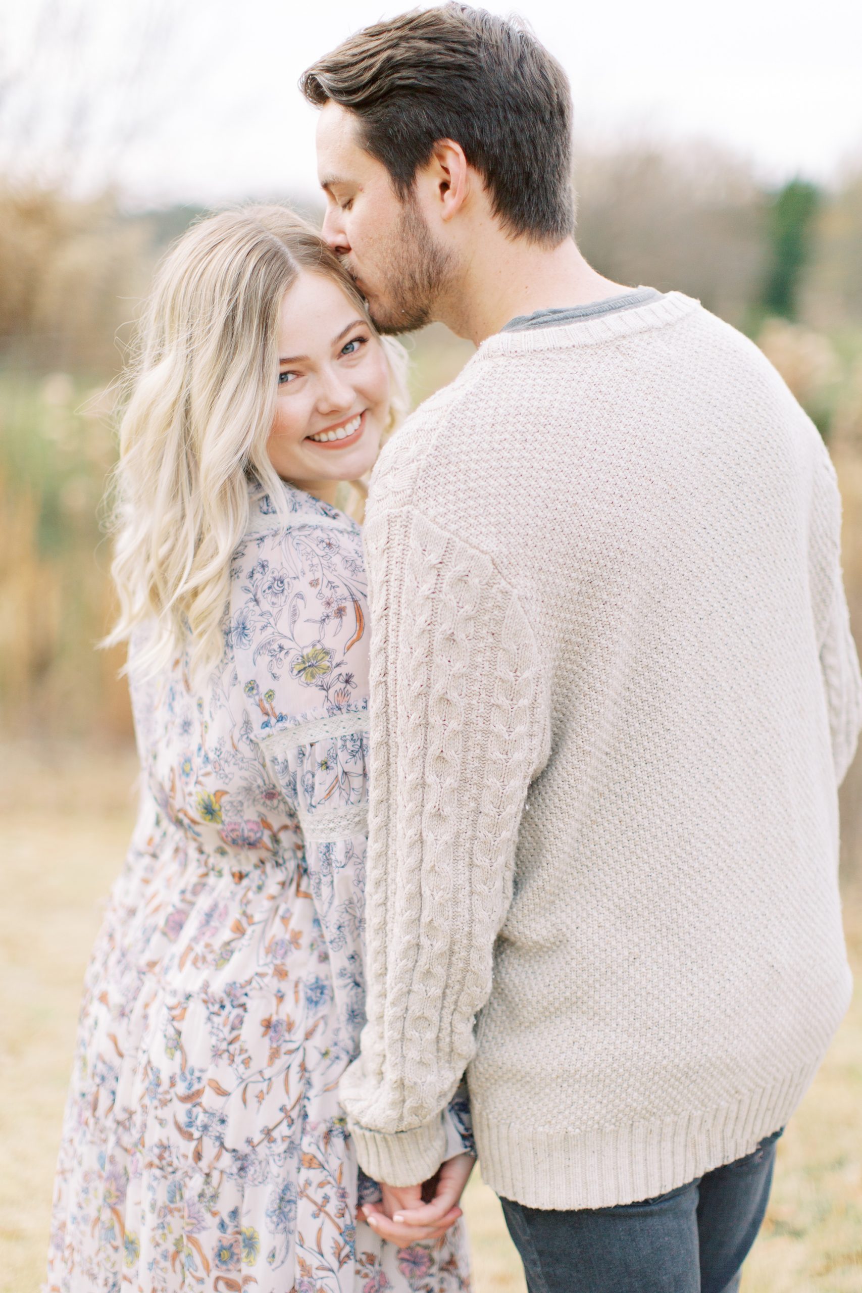 groom kisses bride's forehead during winter North Corner Haven engagement portraits