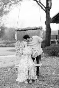 bride and groom kiss on wooden swing at North Corner Haven